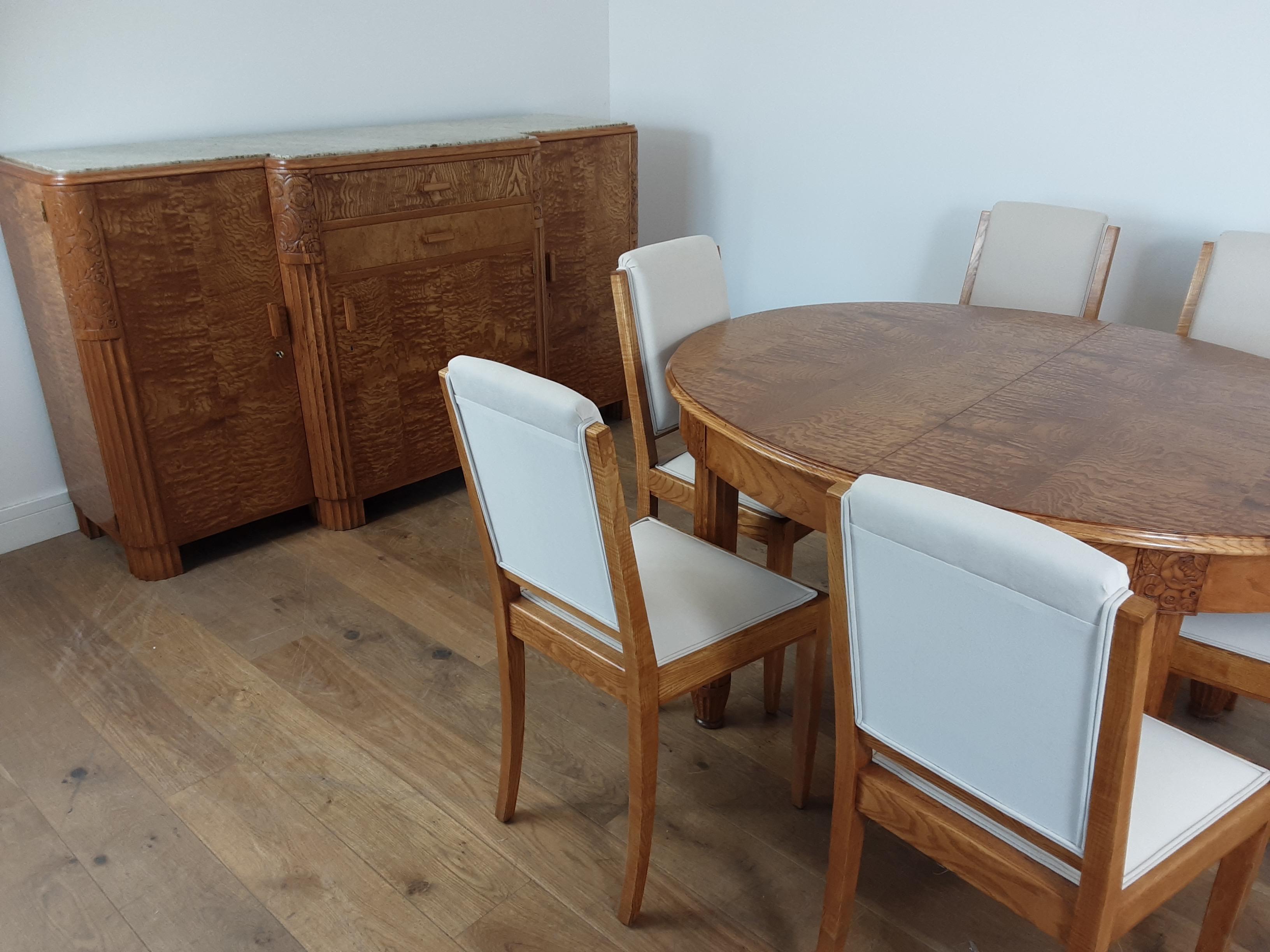 A superb dining suite in a beautiful burr elm and satinwood with ornate floral carvings.
The wood has a lovely golden glow, the legs to the dining table are beautifully reeded ending with a tapered foot.
Just look at the images, truly stunning