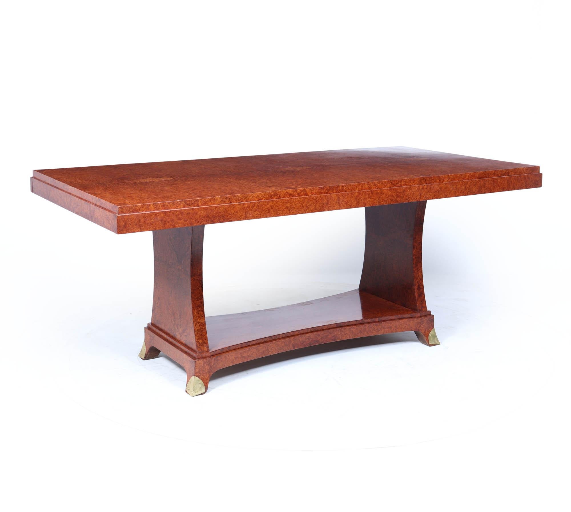 Art Deco Dining Table 
An elegant French Art Deco dining table dating to circa 1925, crafted in richly figured red Amboyna with a warm, lustrous tone throughout. The rectangular top sits on a striking architectural pedestal base, curved inward to