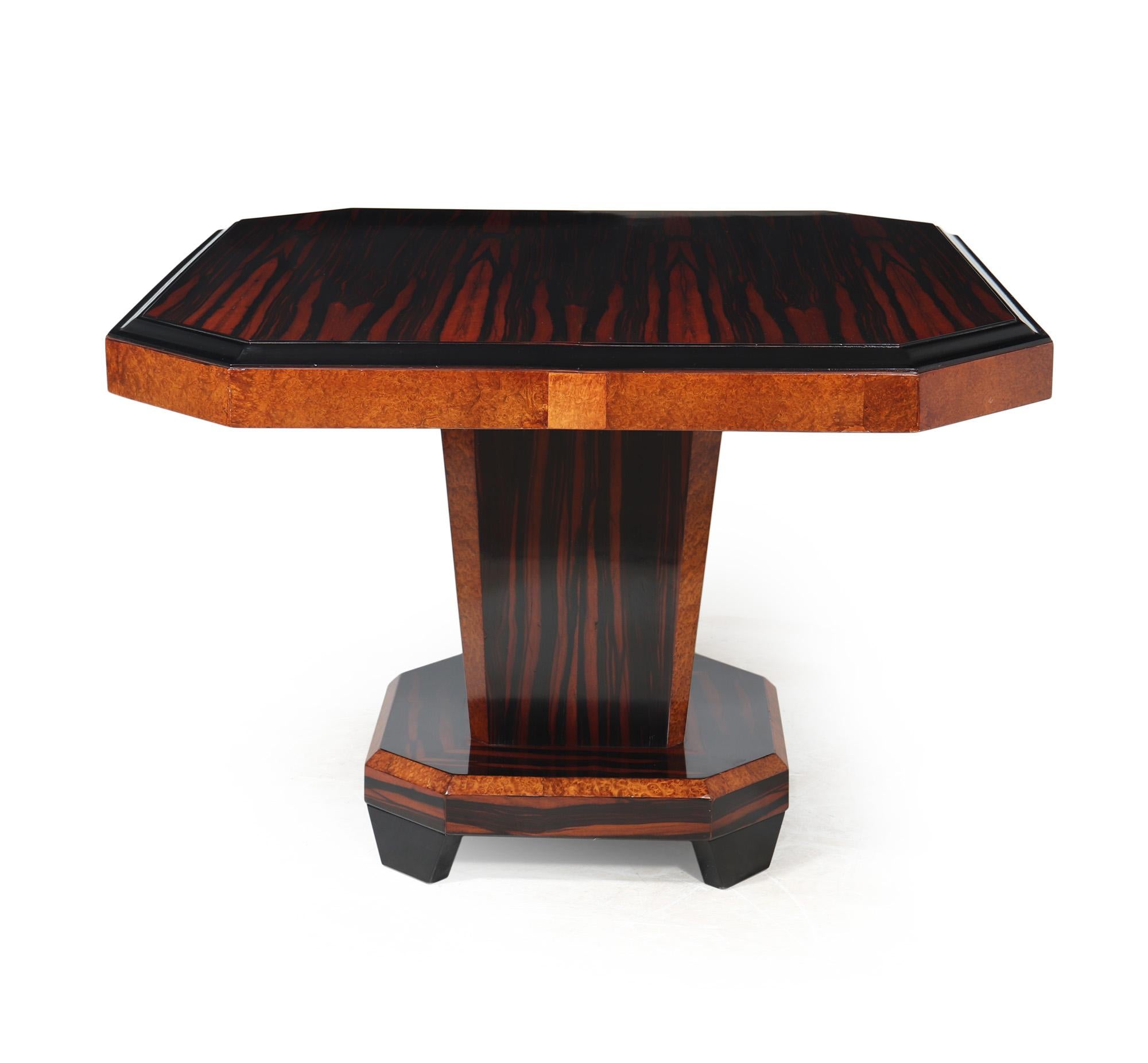 FRENCH ART DECO DINING TABLE
This exquisite dining table, produced in France in the 1920's, has a unique and sophisticated design that captures the eye. Crafted using high-quality Macassar ebony and amboyna, its square top features elegantly canted