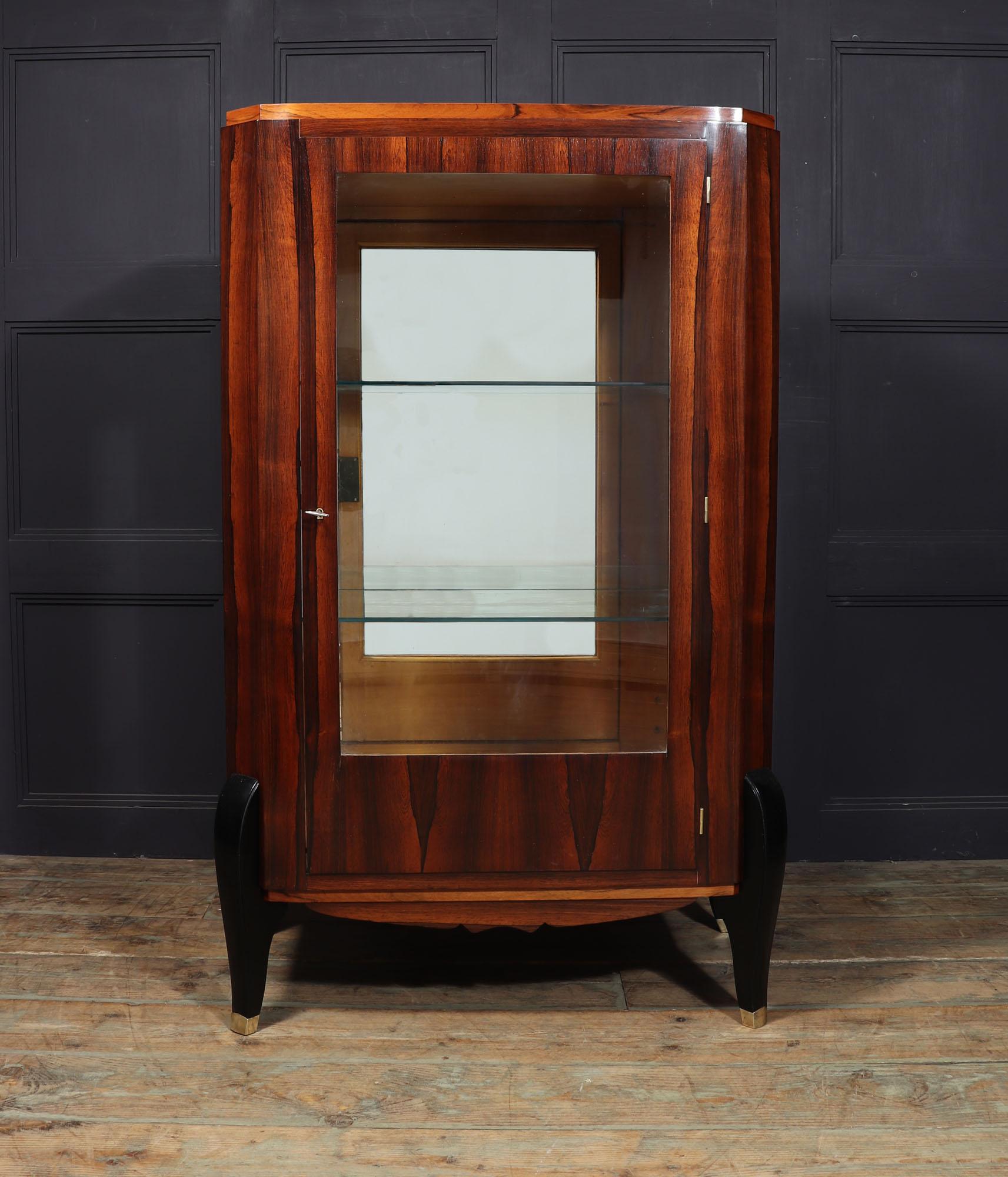 ART DECO DISPLAY CABINET IN ROSEWOOD
A French Art Deco display cabinet in rosewood with canted corners and sting on ebonies oak sabre legs with heavy cast bronze sabots, the glazed door is lockable, it has glazing to each side and a mirrored back