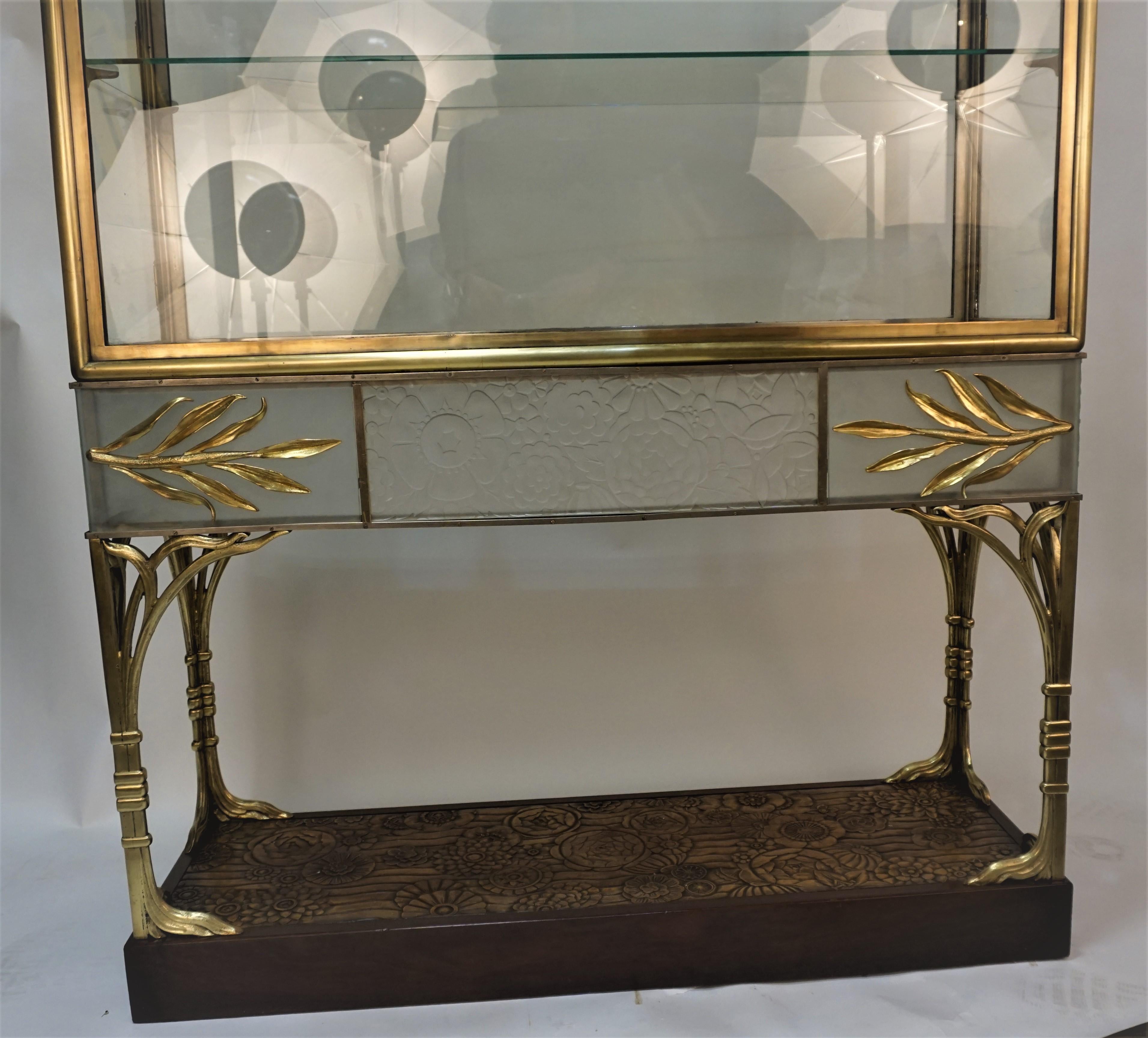 Very rare French Art Deco display cabinet, bronze frame decorative part with flora design molded clear frost glass center front and two sides. The wood base has the same design as molded glass.
There are two side doors in this beautiful cabinet for