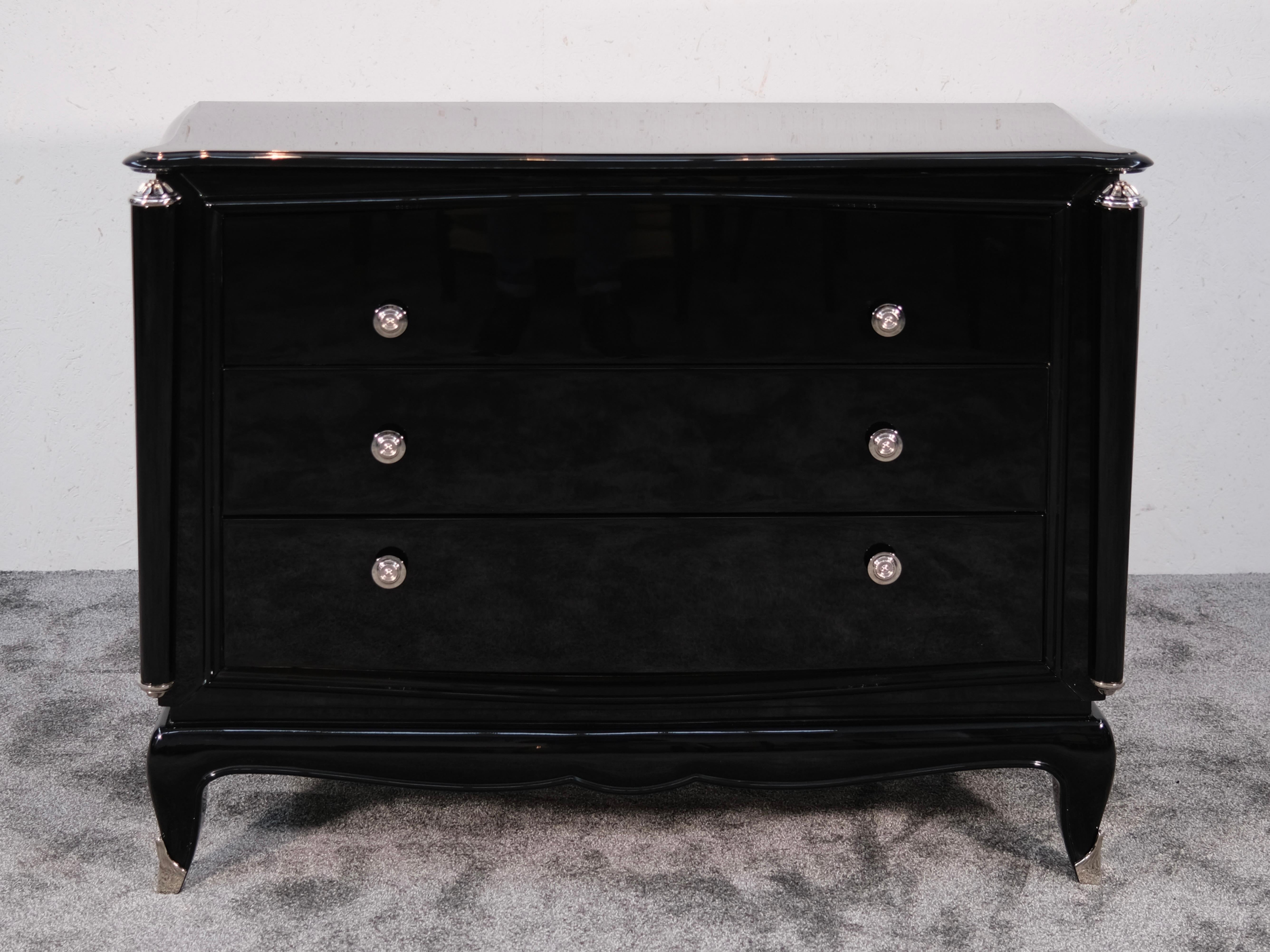 Questa elegante cassettiera francese Art Déco, creata negli anni '40, è un esempio di raffinato artigianato e di design audace. Sapientemente restaurato e rifinito con una profonda lacca nera a specchio, irradia un fascino senza tempo e offre una