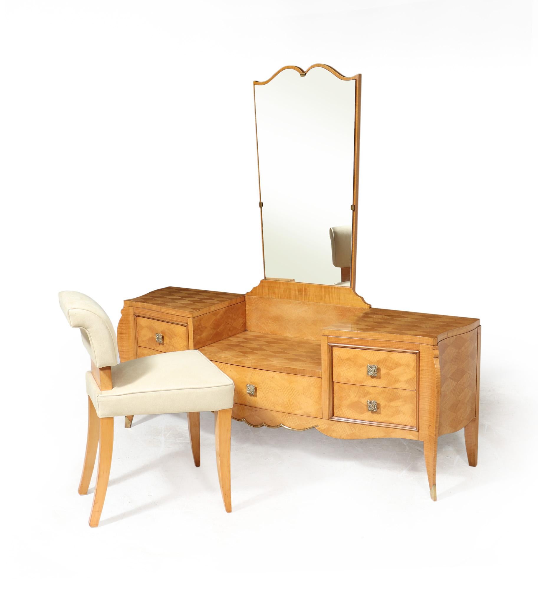 ART DECO DRESSING TABLE AND STOOL 
A French Art Deco dressing tale with serpentine shape covered in sycamore parquetry designed and produced in Paris by Jules Leleu, it has five drawers with mermaid cast bronze handles and sabre legs, the mirror