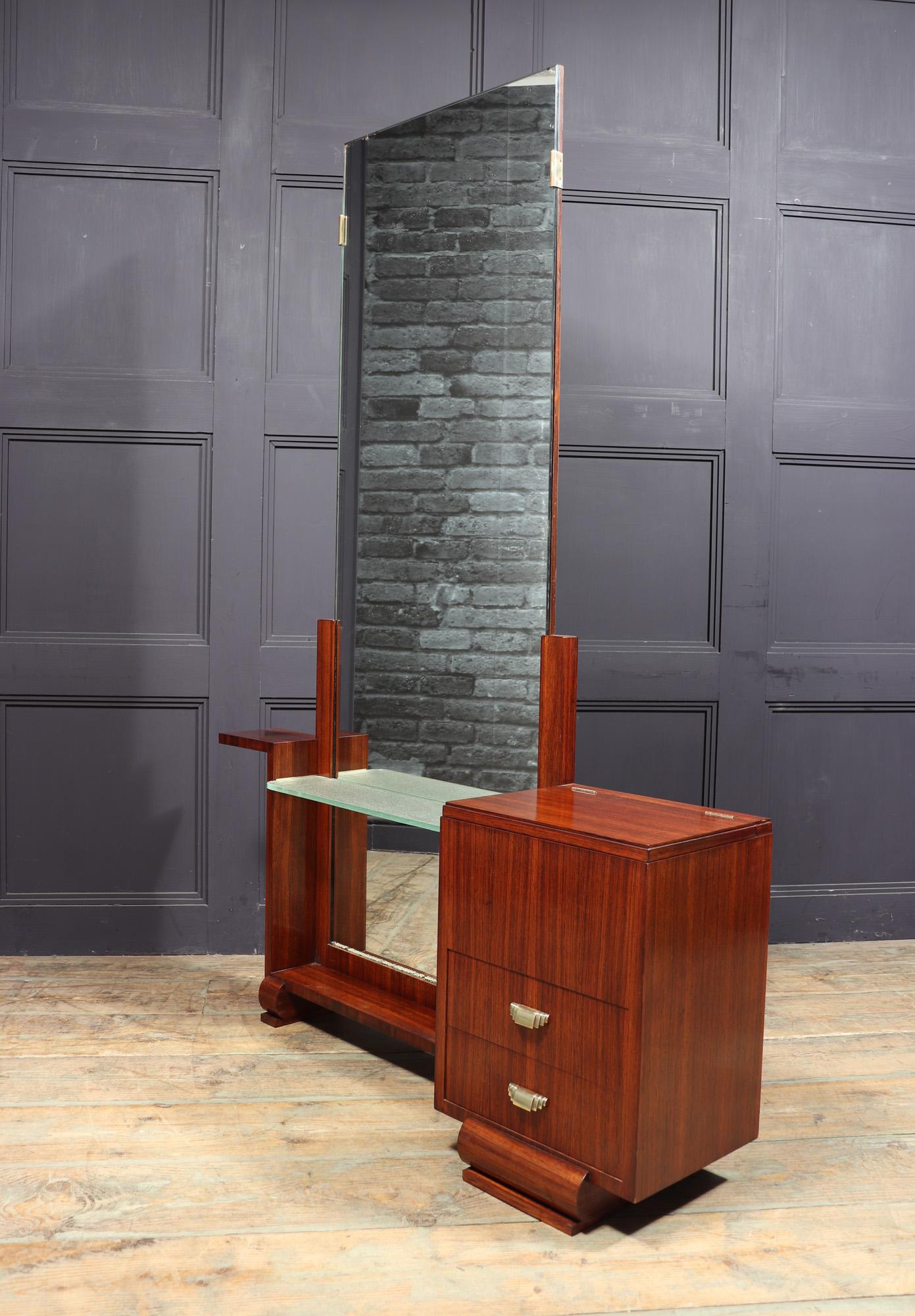 FRENCH ART DECO DRESSING TABLE C1930
A French-made Art Deco dressing table from the 1930s, crafted in palisander with an asymmetrical design. It features two drawers on the right side and a sycamore-lined lift-up compartment adorned with elegant