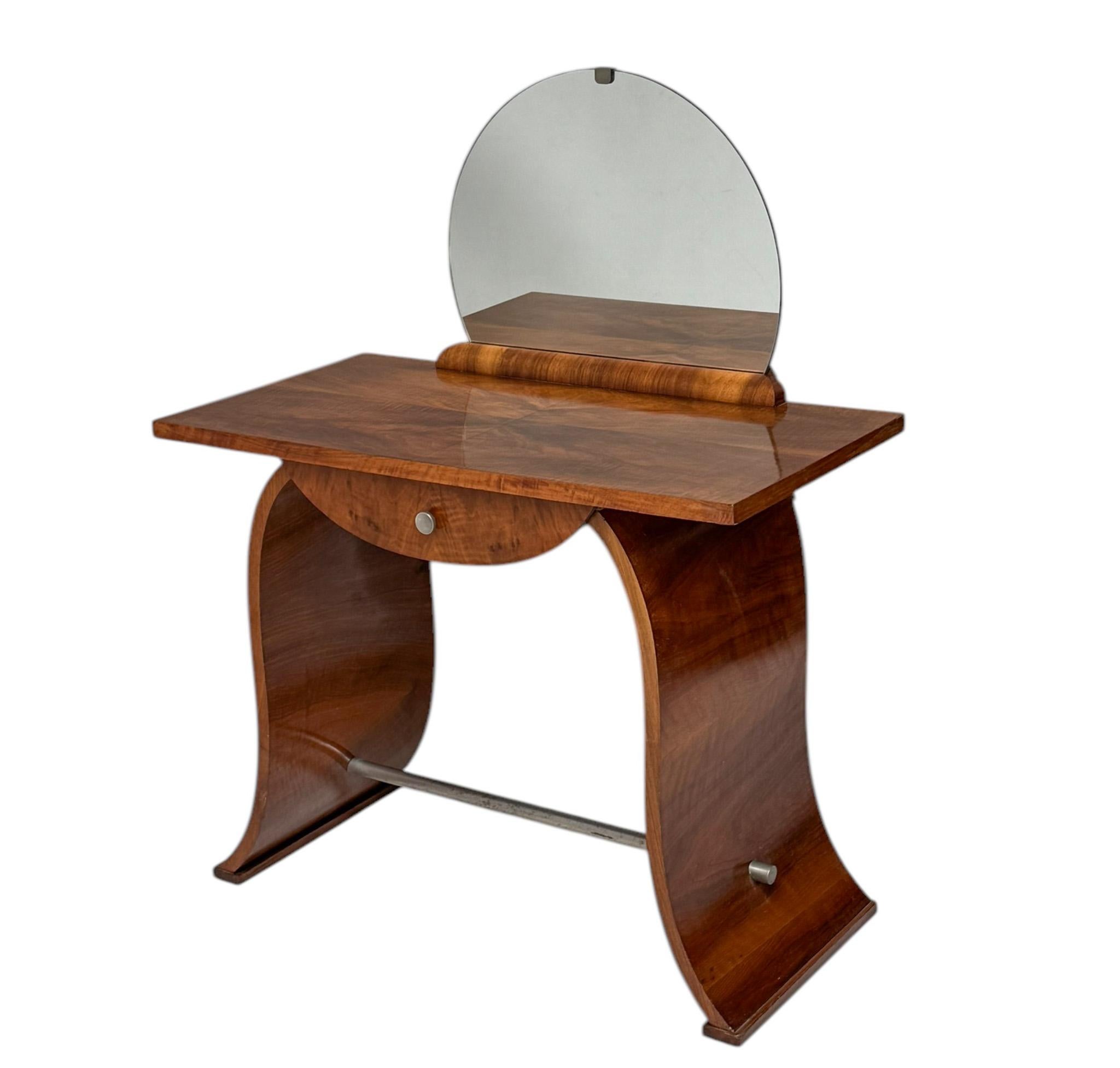 Stunning and elegant Art Deco dressing table or vanity.Striking French design from the 1930s.Original walnut veneered frame with drawer and chrome knob.The sleek patinated chromed foot rail adds a modern contrast while ensuring stability.Original