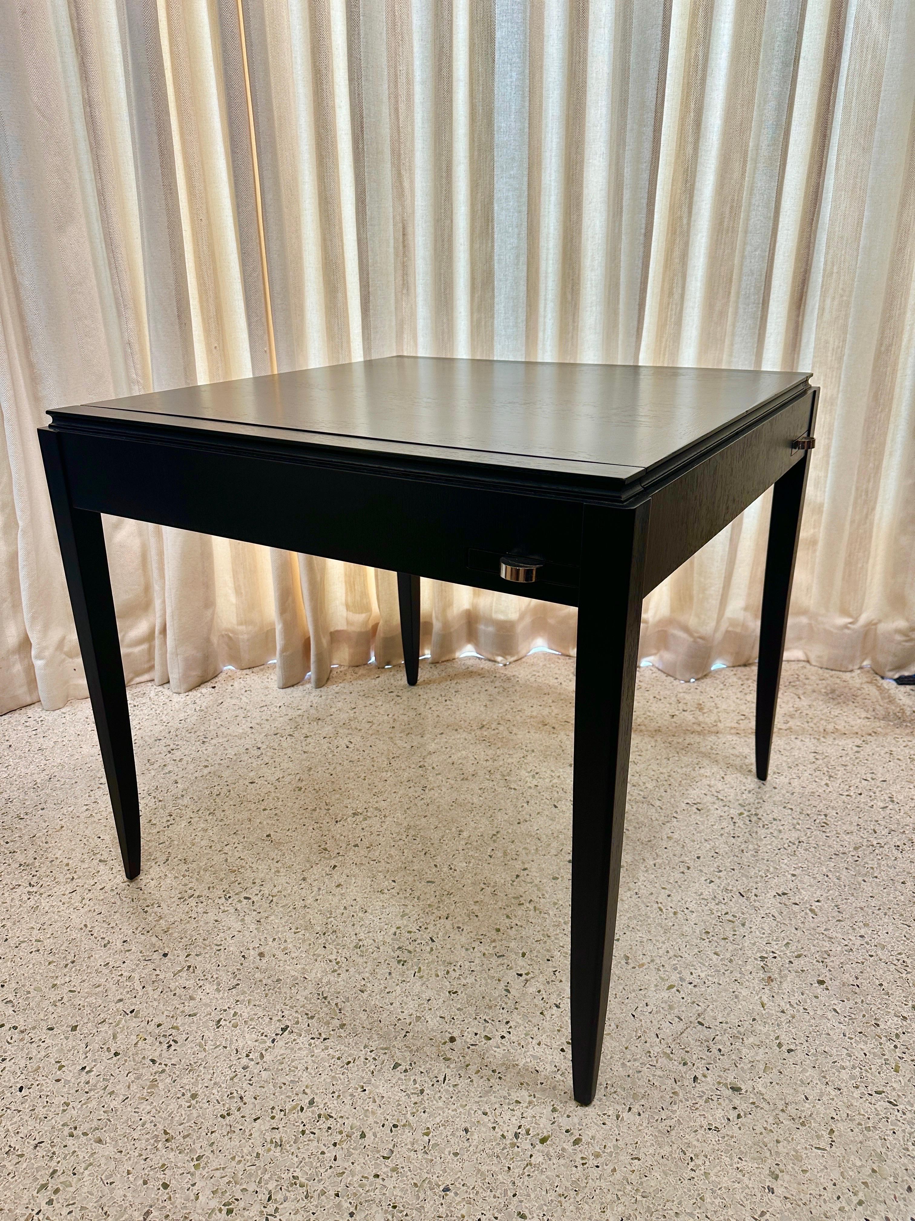 In the style of Jean Pascaud, this 1940's Art Deco period game table features tapering legs, nickel pulls and original ash trays.  The top is able to be flipped for game play and reveals hidden area for game pieces storage.  This has been lightly