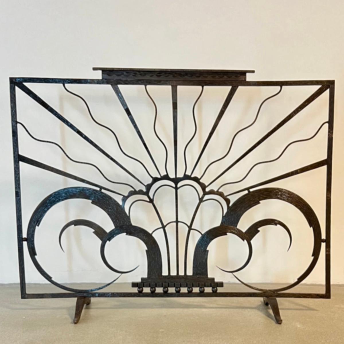 Exceptional  Art Deco hand-forged iron fireplace screen, featuring linear details and scrolls with a beautifully hammered central three-dimensional floral motif, exceptionally finished on both sides of the screen.
