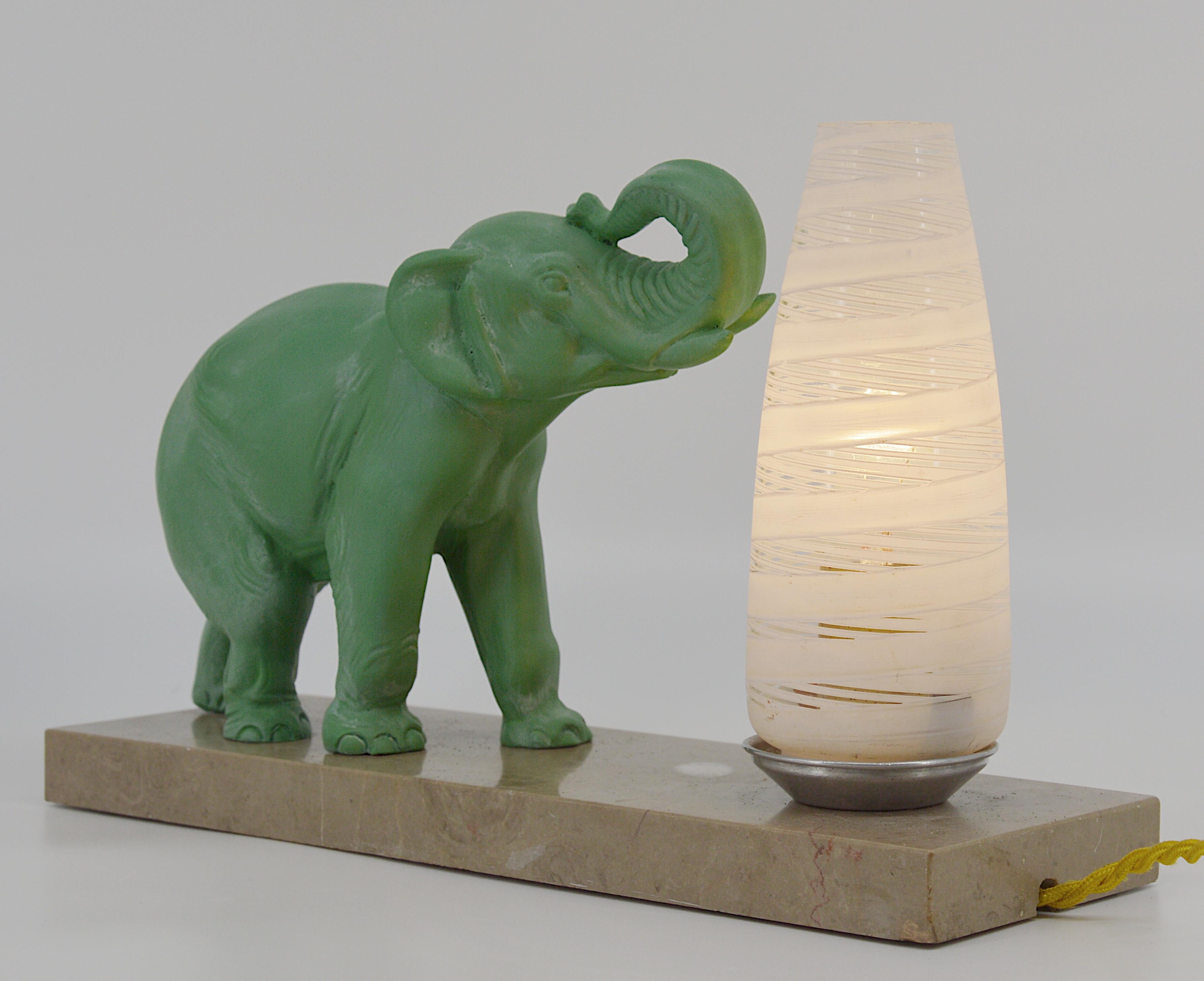 French Art Deco table lamp / night-light, France, 1930s. Green patinated spelter elephant on its marble base. Enameled glass shade. Measures: Width: 11.8