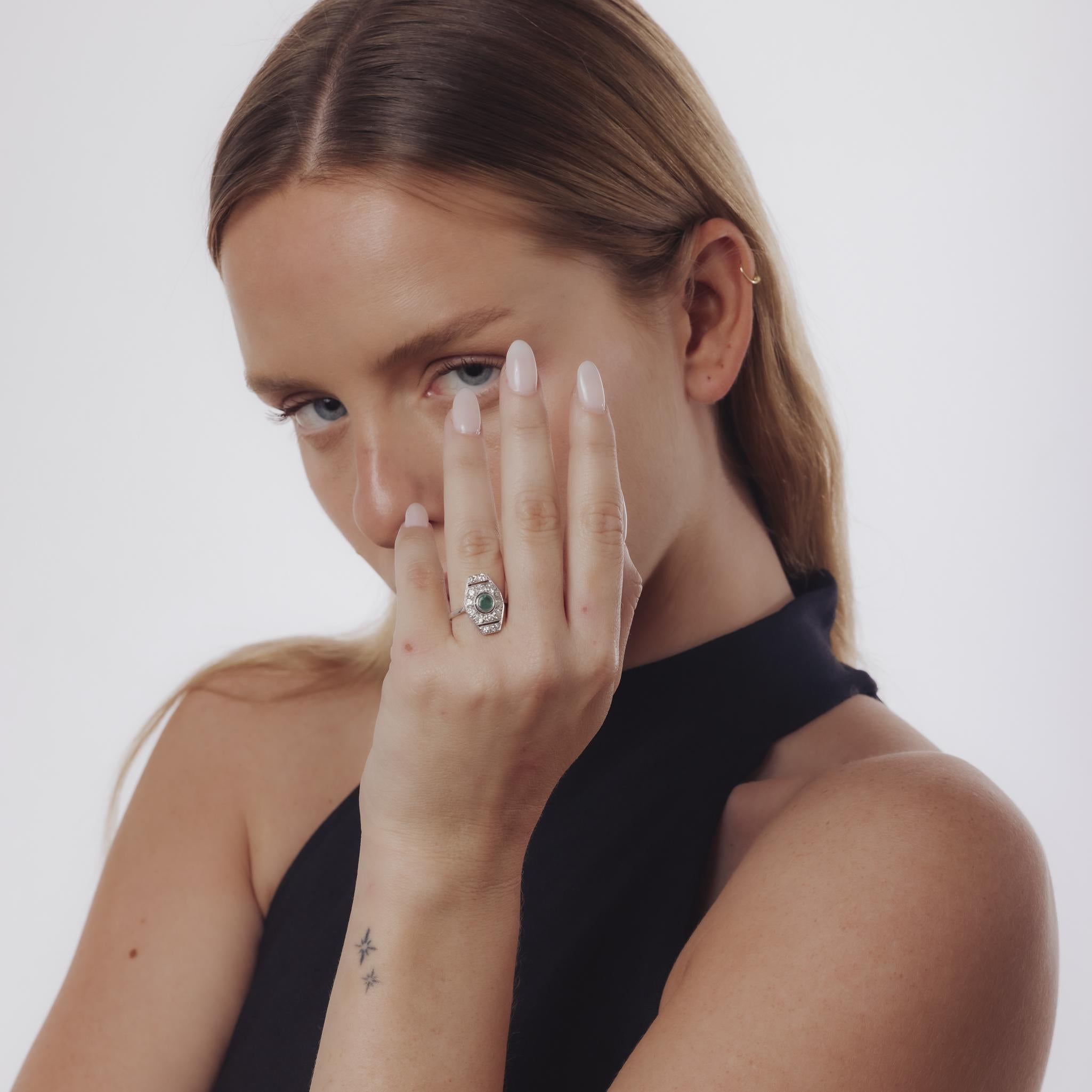 Questo anello Art Deco degli anni '30 presenta un ricco smeraldo rotondo al centro, circondato da scintillanti diamanti di taglio europeo antico in raffinato oro bianco 18 carati.