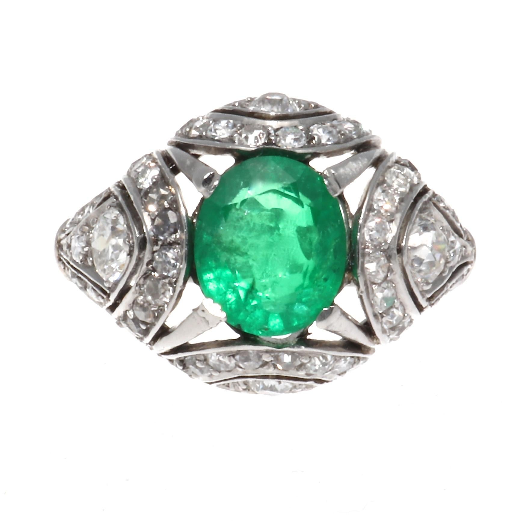 Iconic design that emulates the essence of Art Deco  with geometric shapes and colorful gemstones. Featuring a glowing green emerald weighing approximately 1.30 carats captured in a web of diamonds and finely crafted platinum. Stamped with French