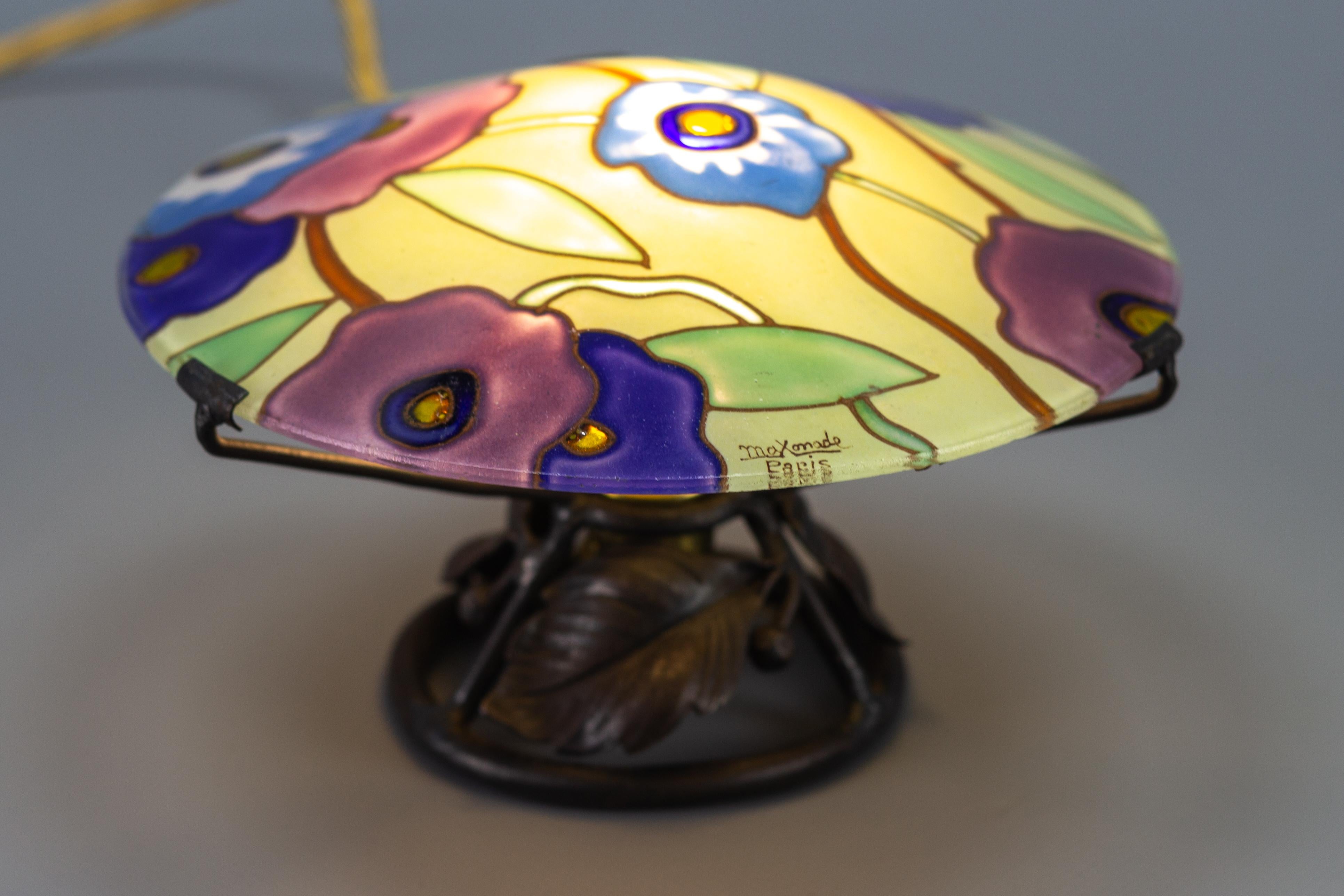 An absolutely rare and charming Art Deco table lamp or nightlight by Maxonade Verrier D’Art, Paris, with stylized polychrome floral pattern decoration. The drawing is hand-painted enamel paint on glass, signed 'Maxonade Paris'. Adorable wrought iron