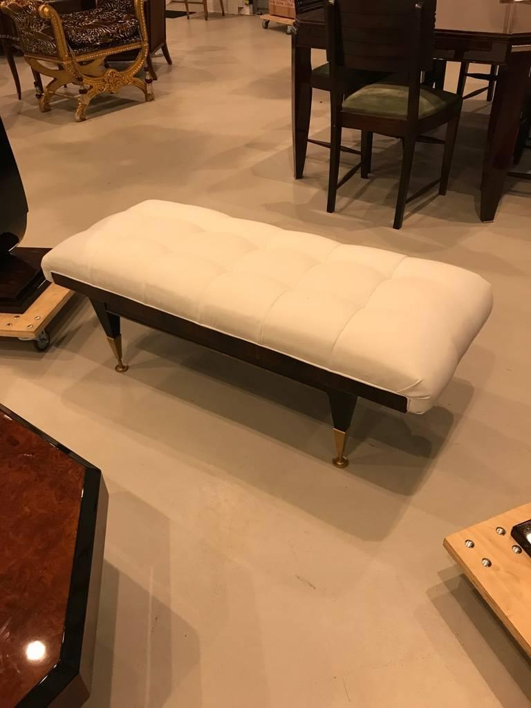 Stunning French Art Deco ebony sitting bench. Recently reupholstered in a white fabric. Having beautiful details and black lacquered legs. Perfect for any room in your home adding deco decor.