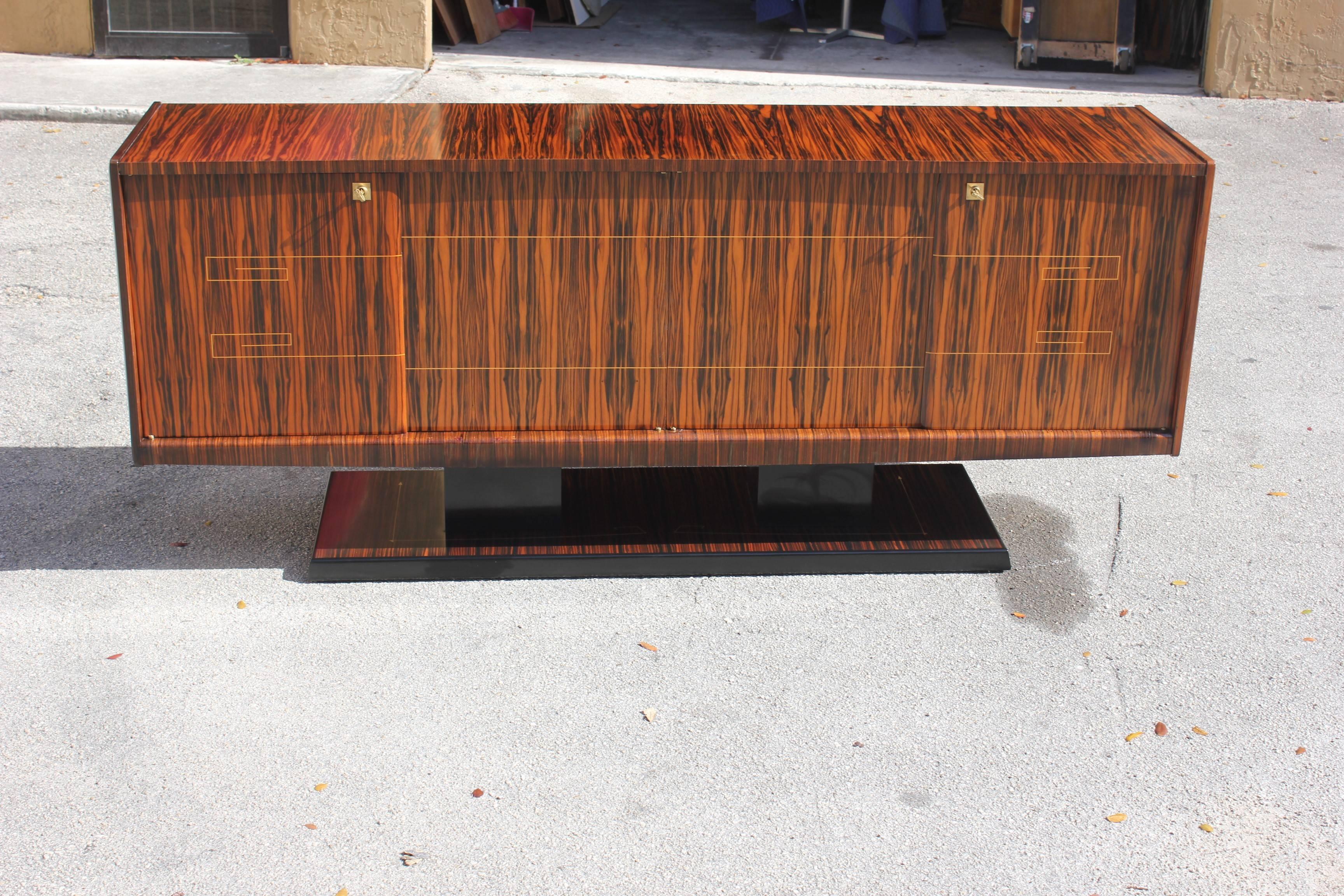 Beautiful French Art Deco exotic Macassar ebony sideboard or buffet, with the cabinetry expertly fitted and balanced and raised upon a platform base Macassar ebony with sycamore inlay. The sideboard are in perfect condition, circa 1940. Size 87 W x