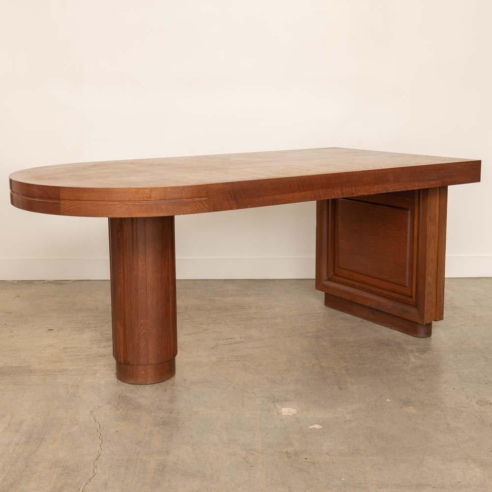 Incredible Art Deco extendable wood desk from France, 1930s. Stunning asymmetrical oak wood top and a pull out leaf on one side. Original finish shows great age and patina. Stunning statement piece and perfect as a desk or library table. Includes