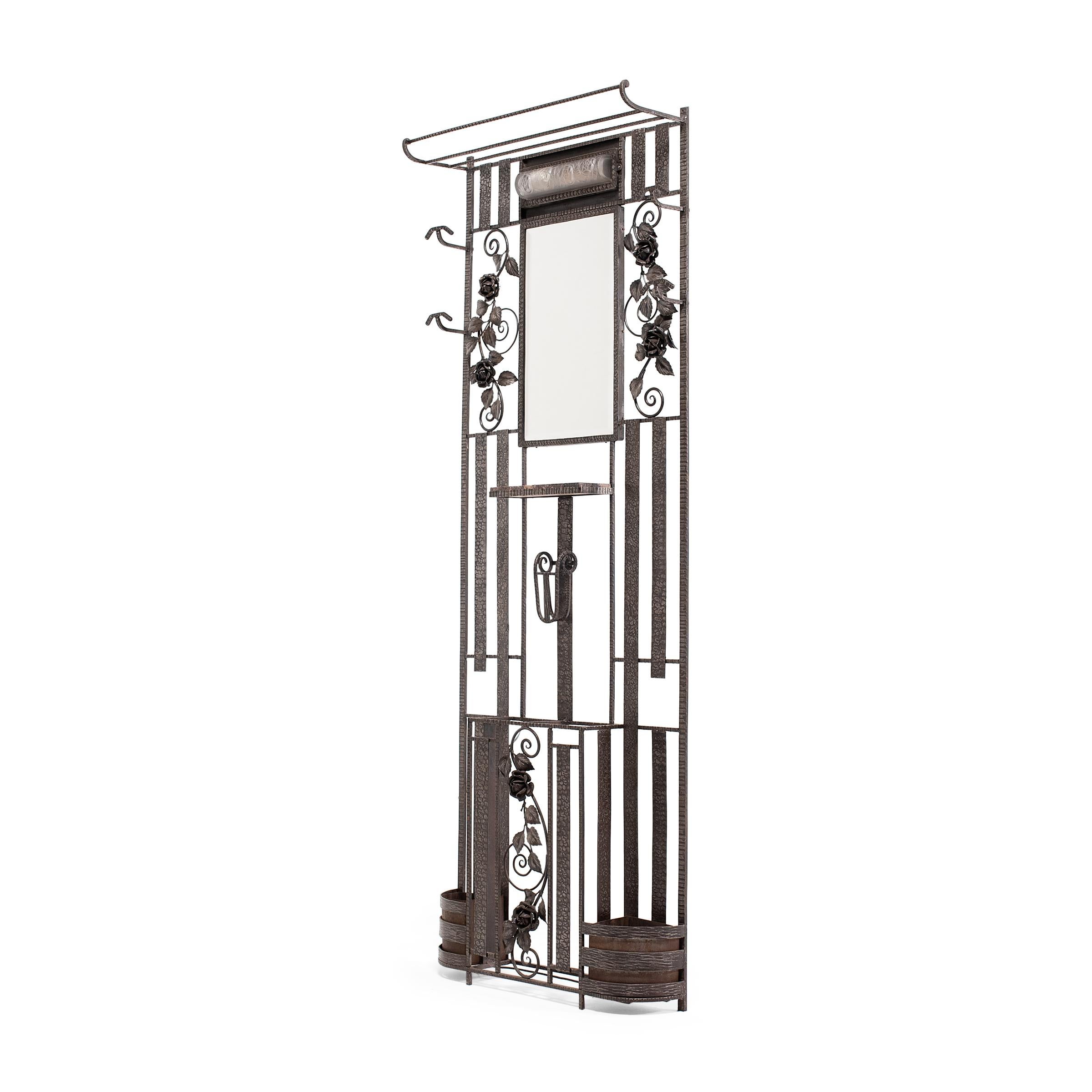 This fantastic French wrought iron foyer rack or hall tree dates to the Art Deco period of the 1920-30s. The coat rack is wonderfully decorated with a hammered and crimped texture, with panels of finely sculpted roses atop spiral scrollwork. The