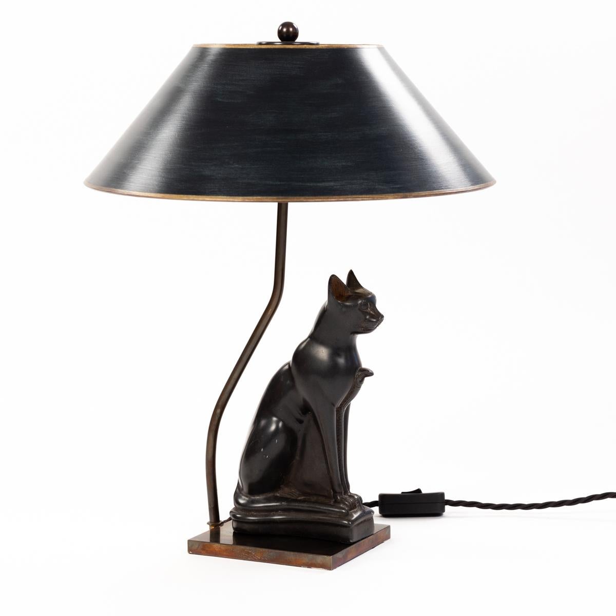Figural table lamp Sitting stone cat god France 1940-ies.

The object is from the Art Deco period and very finely worked in stone.
The animal sits majestically and straight and radiates a certain calm.
The lamp construction of burnished brass was