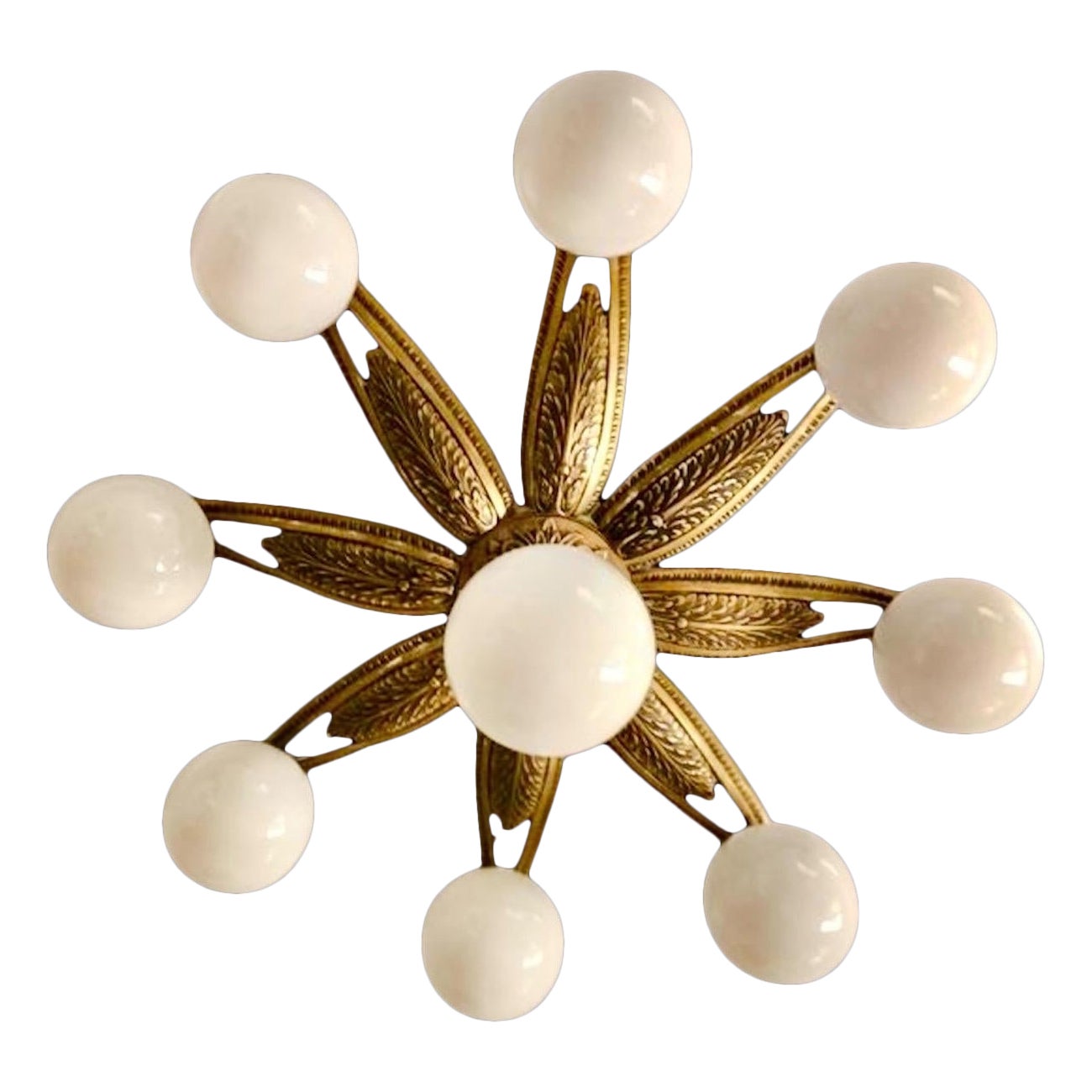 Lámpara de techo Art Decó en forma de flor o sol, en bronce grabado y fundido, con cristal de leche opalino. Francia, años 30. Esta lámpara de techo presenta un estilizado motivo de flor o sol. En el centro hay un hermoso globo de cristal opalino