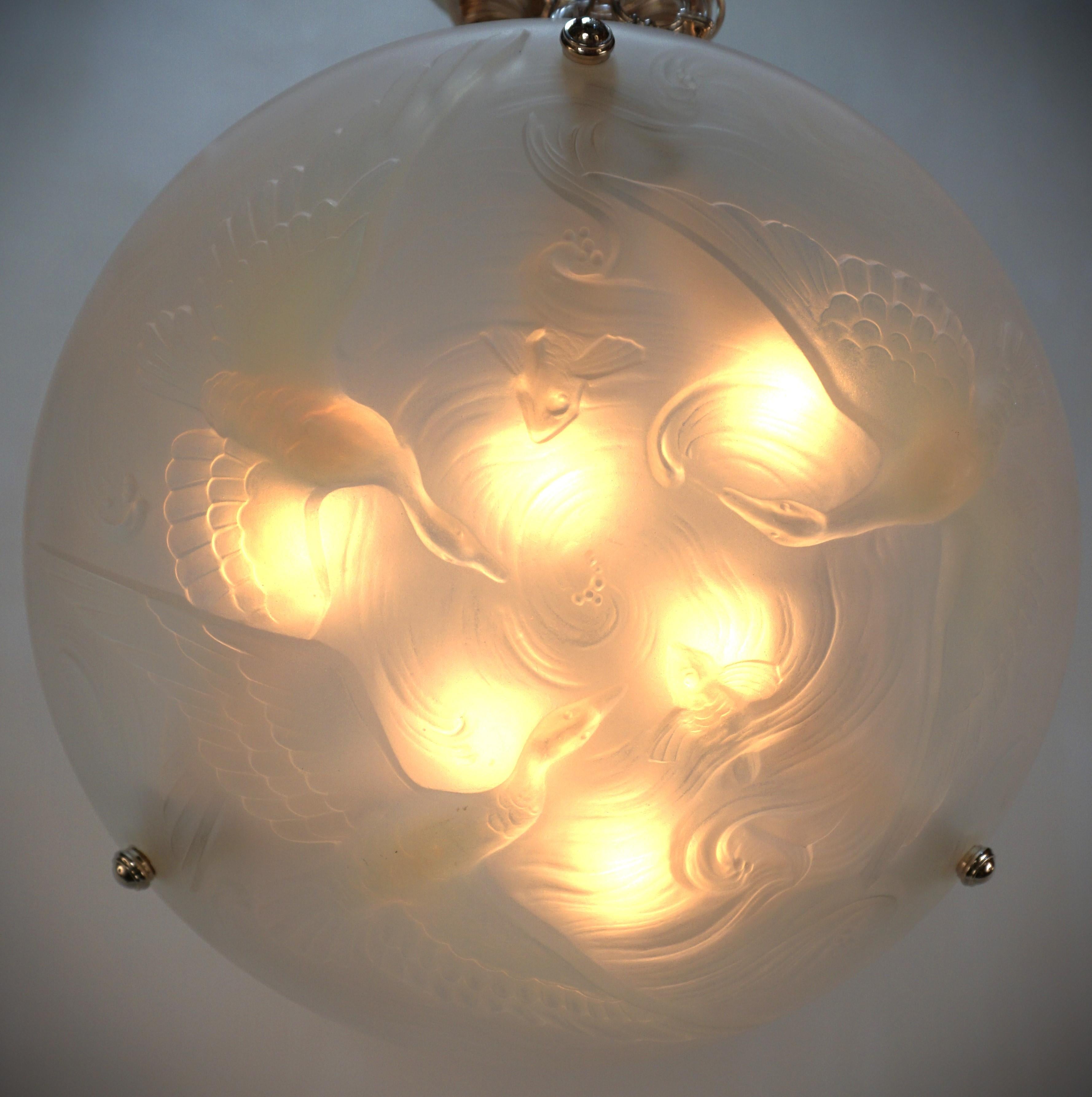 A wonderful Art Deco chandelier. This chandelier features a beautiful flying bird and fish design in light color honey blue opalescent frost glass with nickel on bronze hardware.
Professionally rewired and ready for installation.
Six lights, 60watts