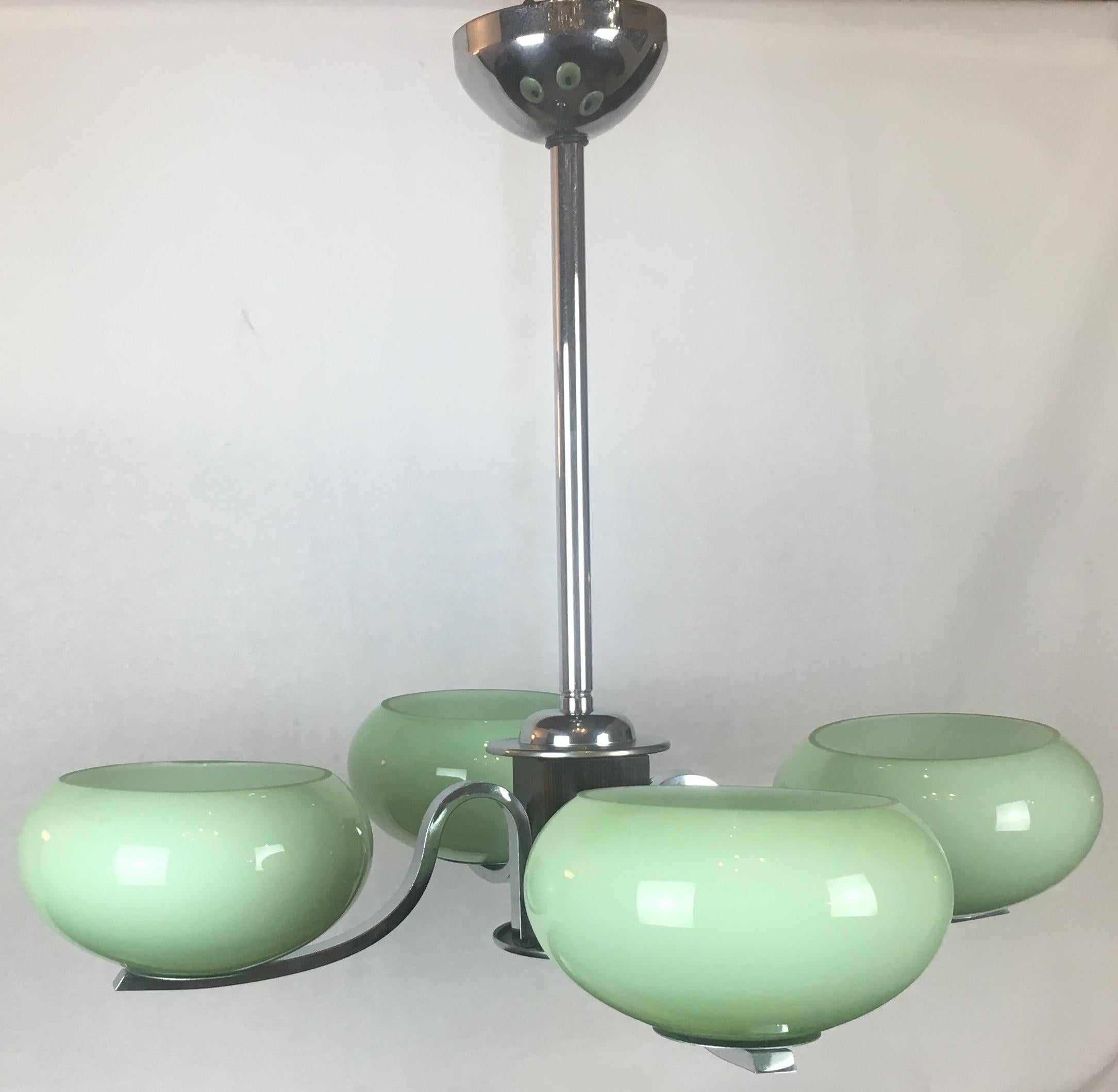 A gorgeous French Art Deco chandelier with pale green opaline shades. A very nice decorative piece that would look great in a midcentury style home, as well as, any contemporary setting.

This light is made of rosewood and chrome. Originates from