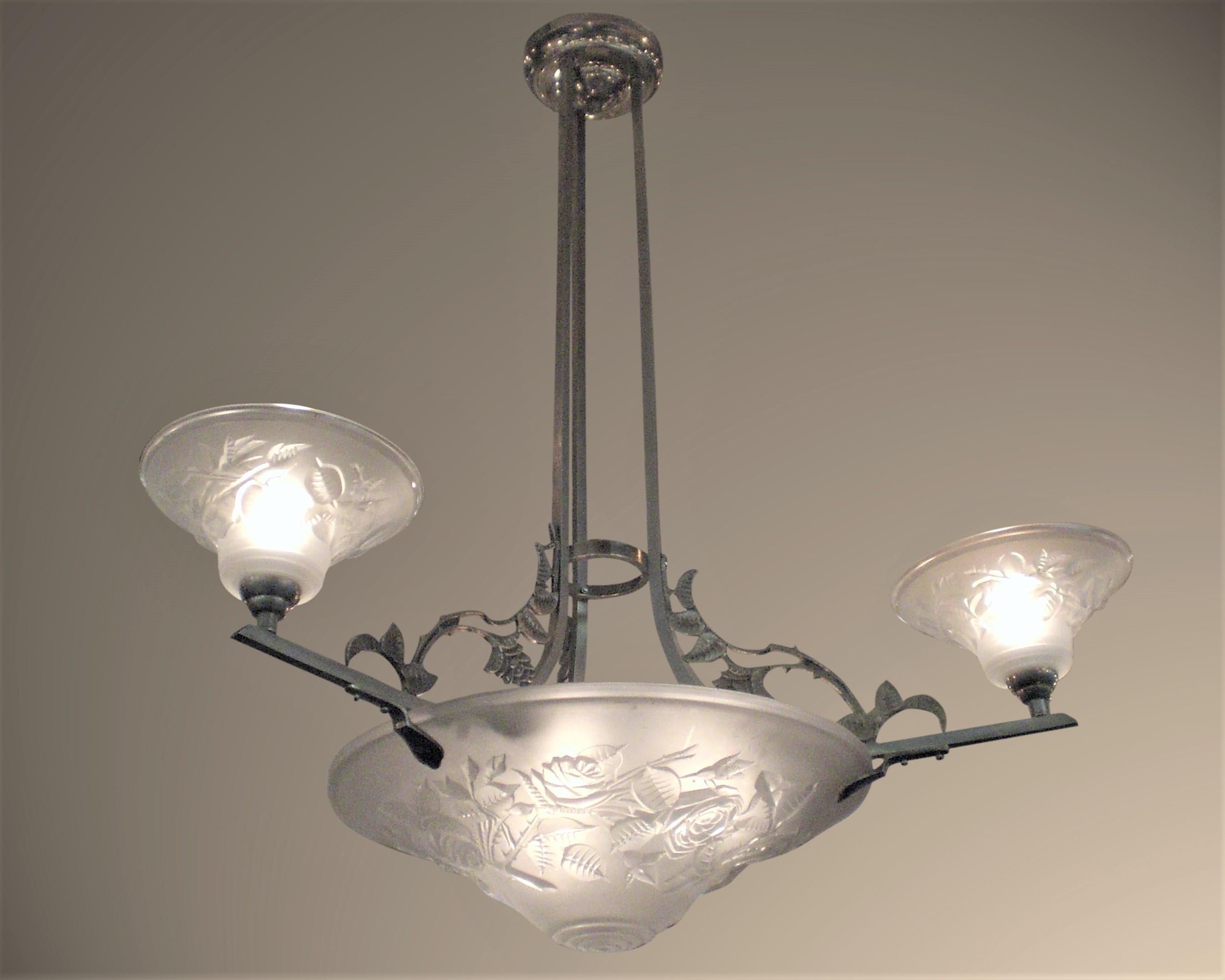 French Art Deco chandelier signed Maynadier, circa 1928, with a stylized motif of trellising briar rose vine and leaves. Three glass tulip shades with matching rose detailing focus light upward. Trailing rose motif is repeated on the satin
