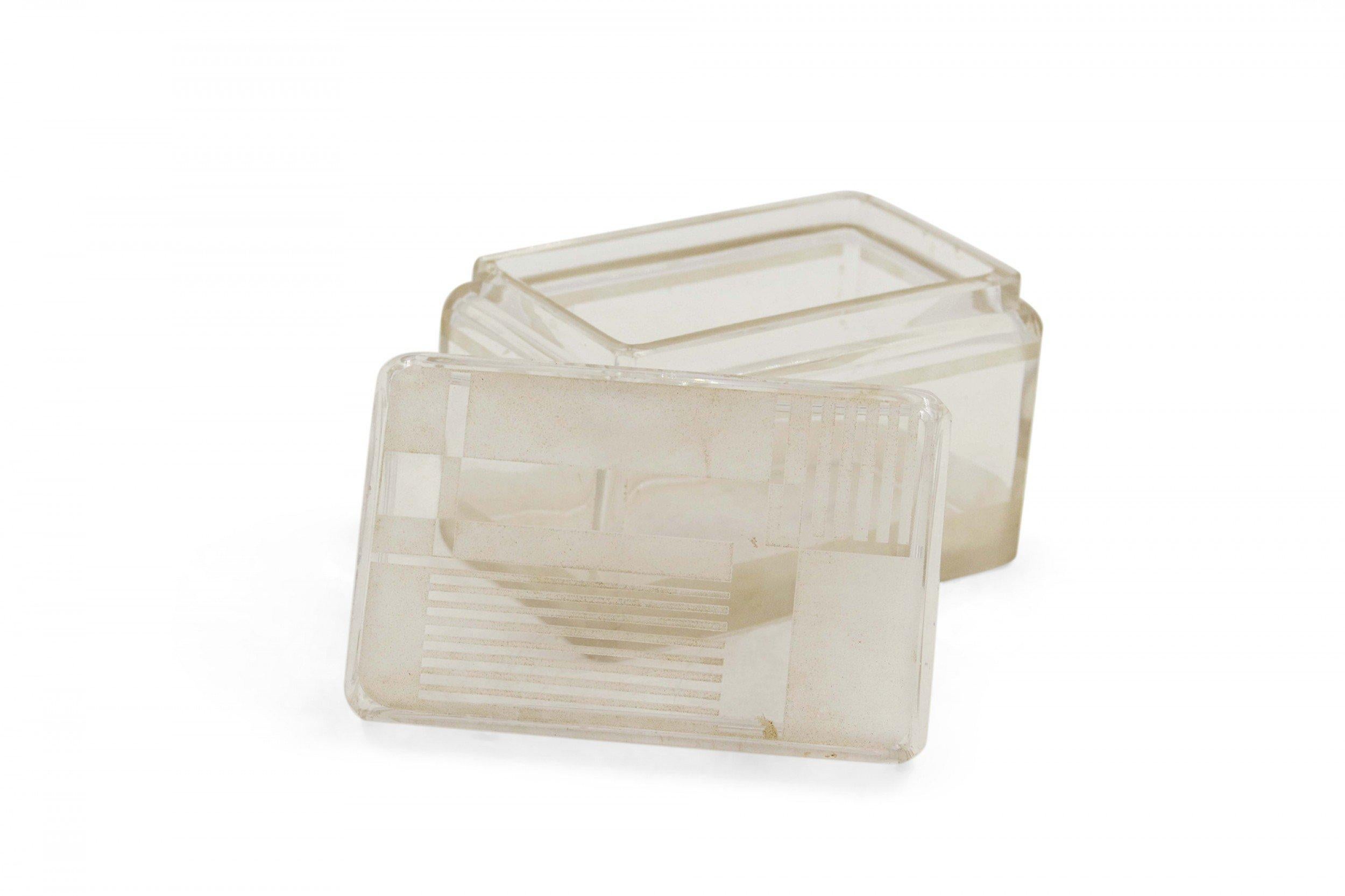 Boîte rectangulaire en verre dépoli de style Art déco français, aux bords arrondis, avec un couvercle incisé de motifs géométriques et un poinçon à la base.
       
