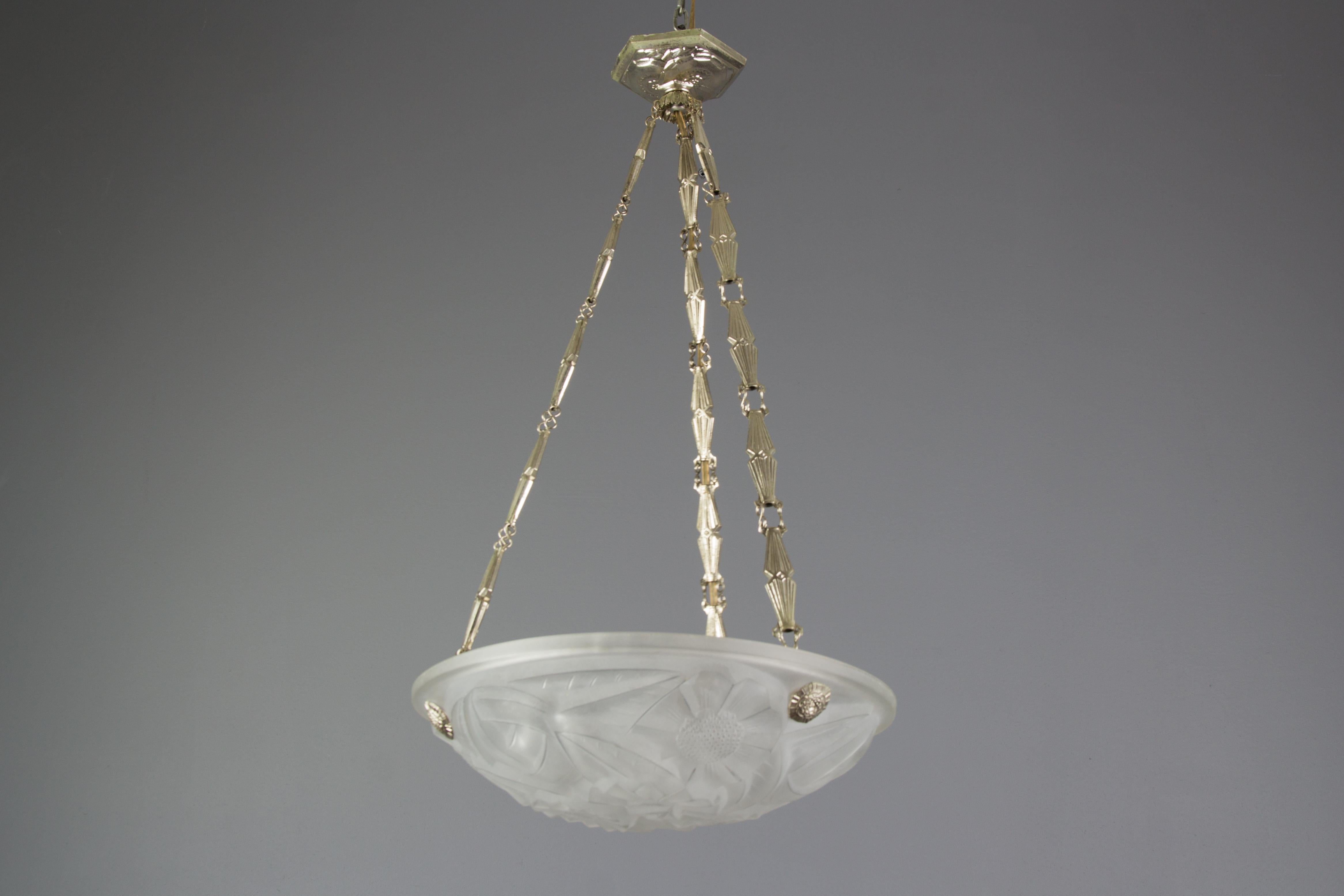 French Art Deco pendant chandelier with frosted pressed glass shade by Degue. Beautifully shaped glass shade features stylized flower decoration, glass surface signed 