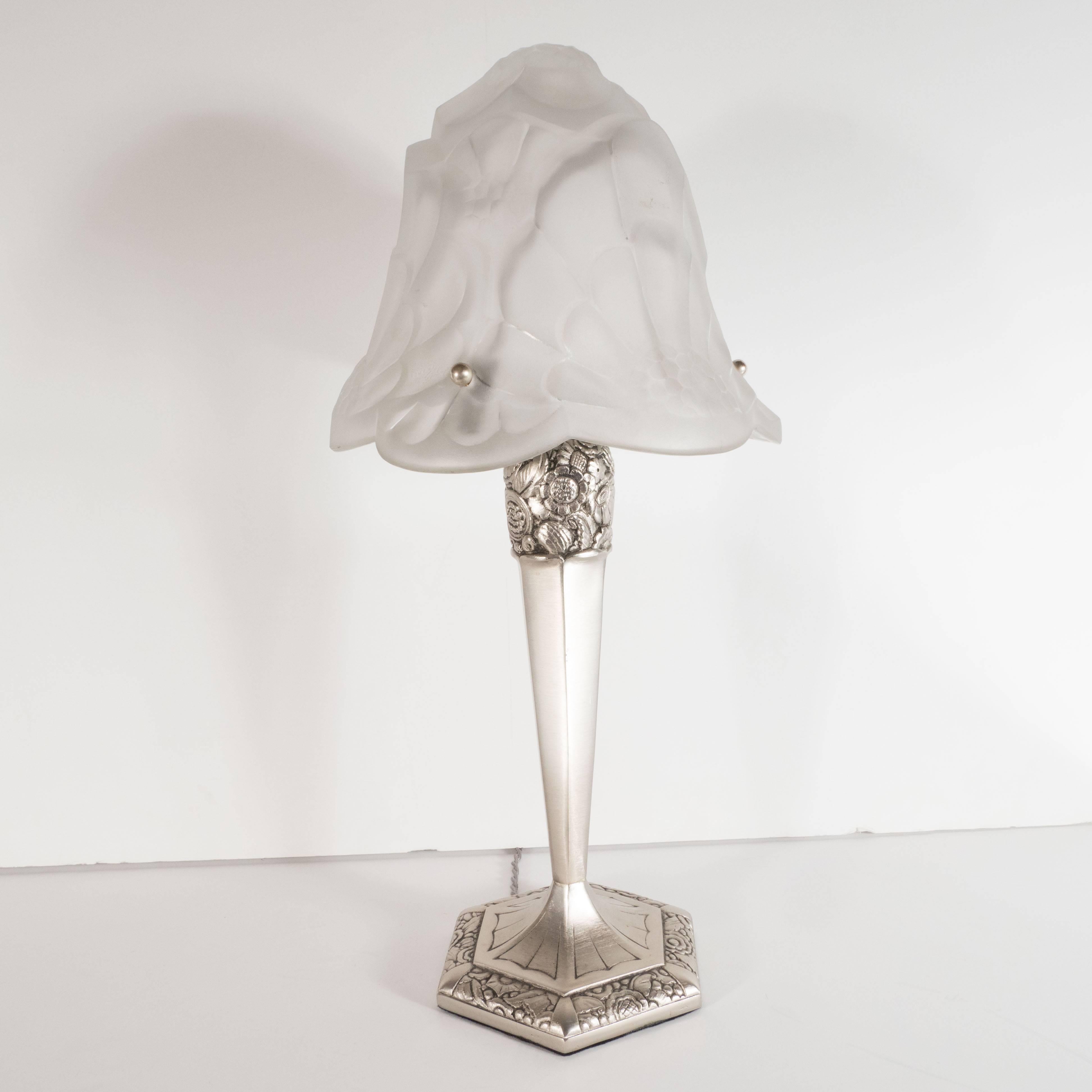 This rare and iconic Art Deco table lamp was realized by the fabled glass studio, Degue in France, circa 1930. It features a hexagonal base with a rod that expands towards its apex and features cubist foliate detailing at its top and the outer band