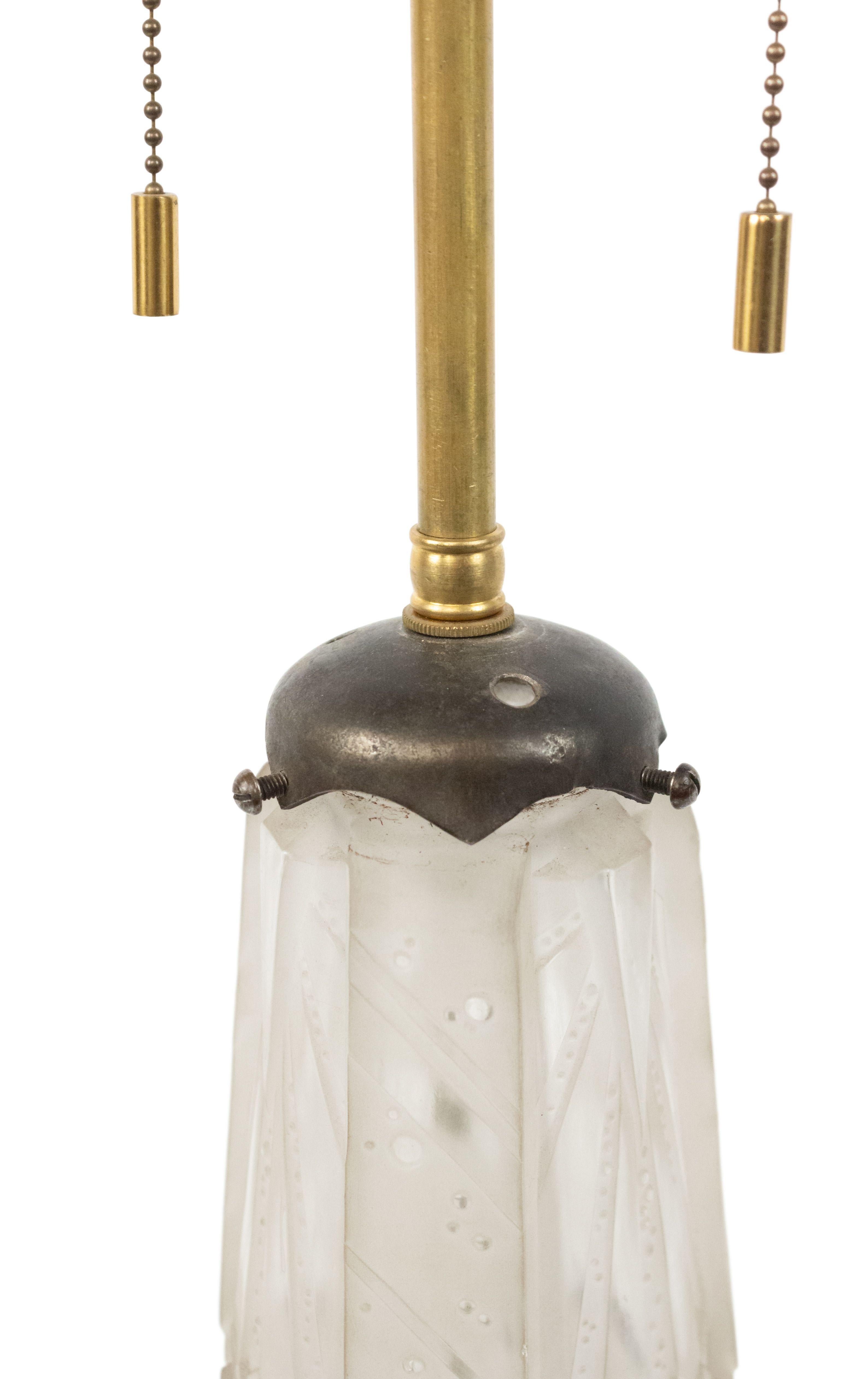 French Art Deco table lamp with frosted glass geometric design resting on a round iron base.