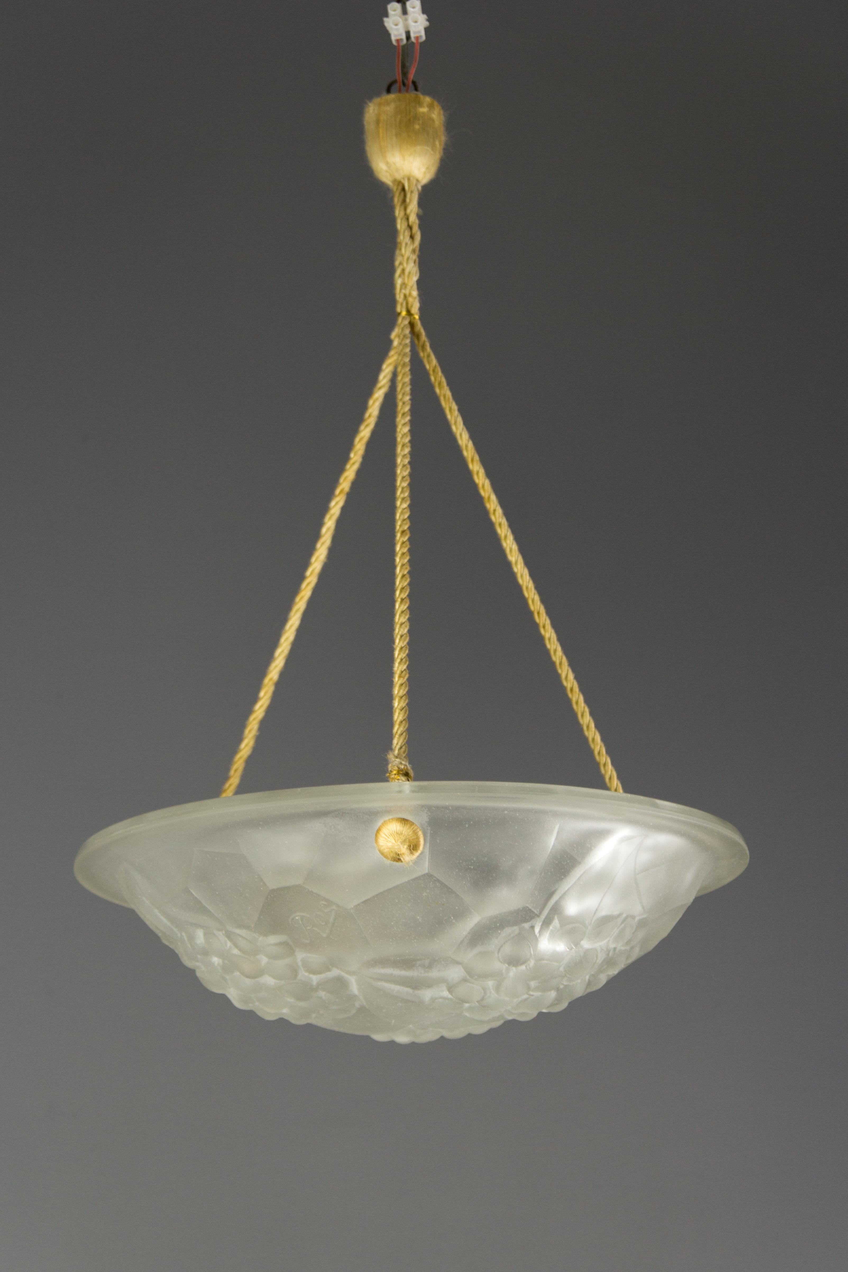 Beautiful French Art Deco pendant light/chandelier signed “ROS” for David Guéron (1892 -1950), Degue label glass maker artists from the 1930s. Clear frosted molded glass shade with a relief decor of flowers and leaves. Held by three cords with a