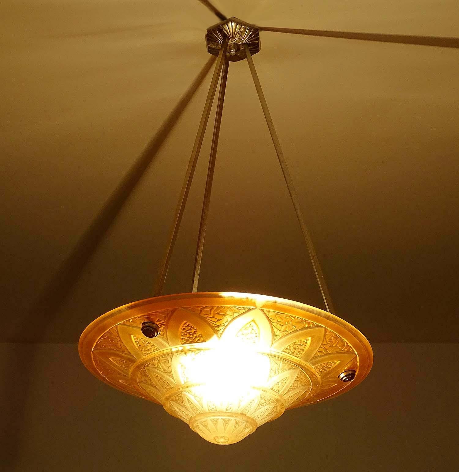 French Art Deco chandelier with molded glass shade showing geometric patterns inspired by ancient Egypt papyrus columns found in the Karnak temple, thick relief . Suspended on nickel plated bronze and brass fixture.
Dimensions:
H 25.6 in. x Dm 13.78