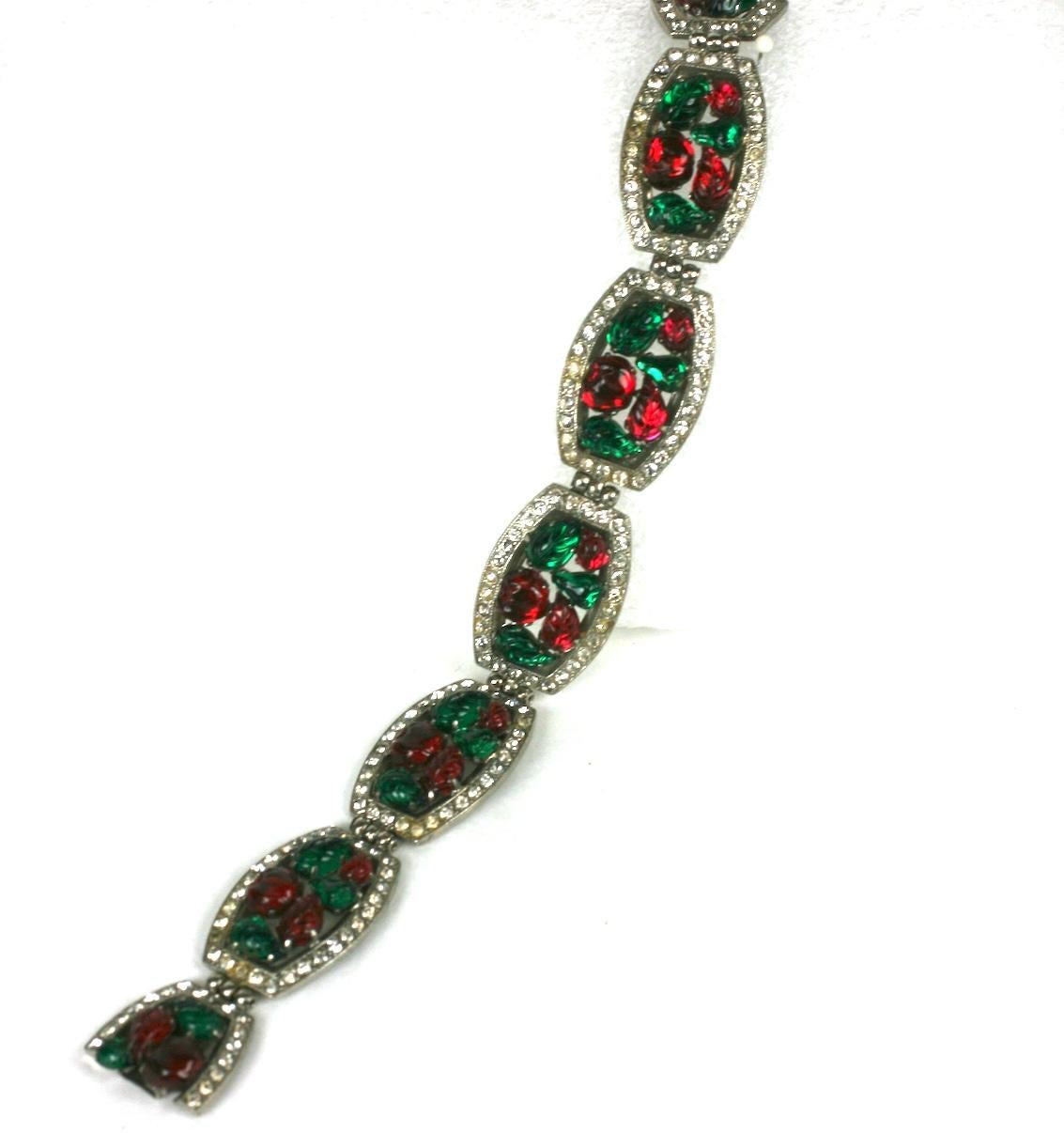 Wonderful French Art Deco Tutti Frutti style six panel link bracelet. Each oval formed link surrounded by crystal pave, the centers of prong set, hand molded faux emerald and ruby french glass fruit pointed leaves. Set in rhodium plate