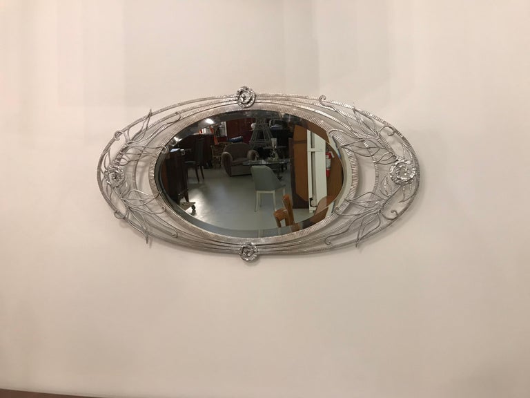 French Art Deco wall mirror with geometric and floral motif details. Can be hung vertically or horizontally. The frame has been re plated in polished nickel. The mirror is in excellent condition.