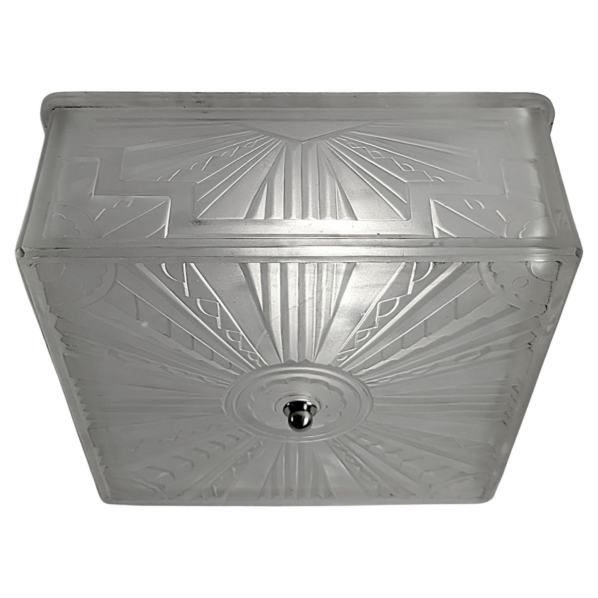 Encastrement de forme carrée de l'Art déco français par Genet et Michon, décoré de motifs géométriques de l'Art déco, en très bon état. L'abat-jour est en verre dépoli transparent monté sur une tige centrale. Le luminaire a été replaqué en nickel et