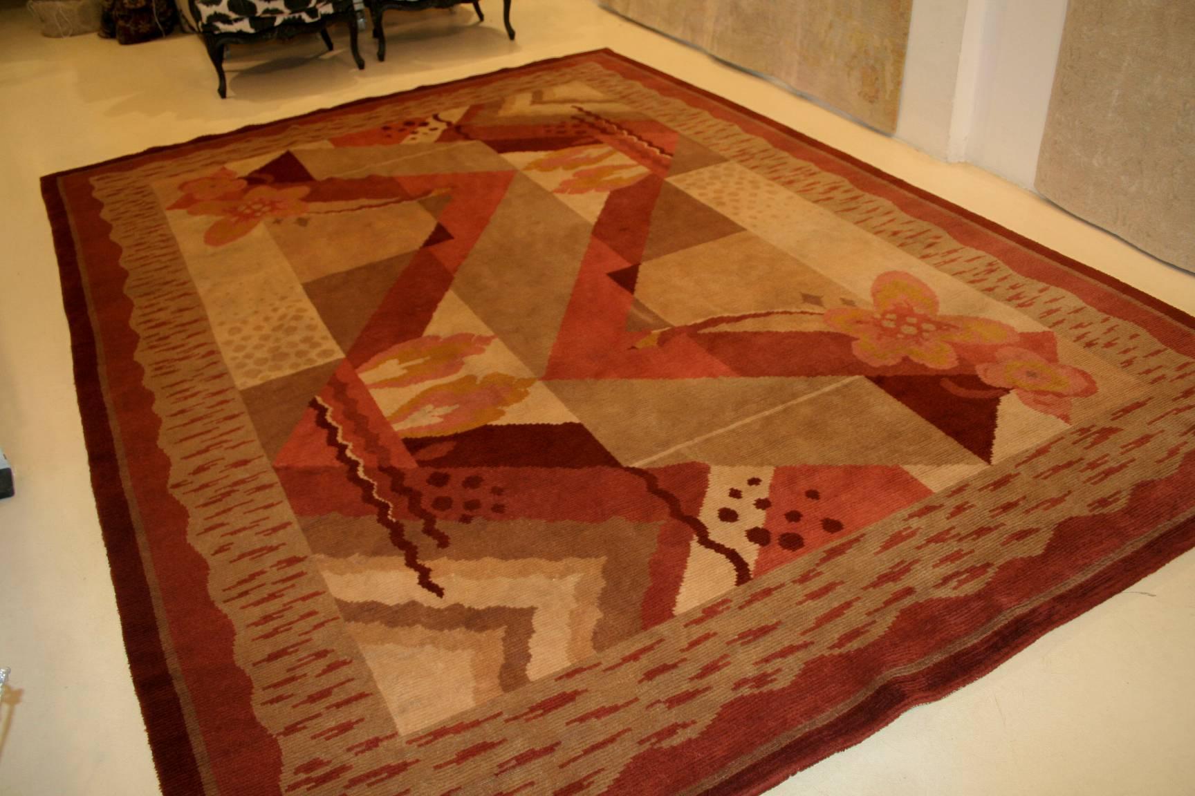 A rare and original French Art Deco rug featuring a characteristic geometric pattern. Designs such as the one seen here are influenced by Cubism and often seen on carpets such those woven by Ivan da Silva Bruhns. The floral embellishments are a