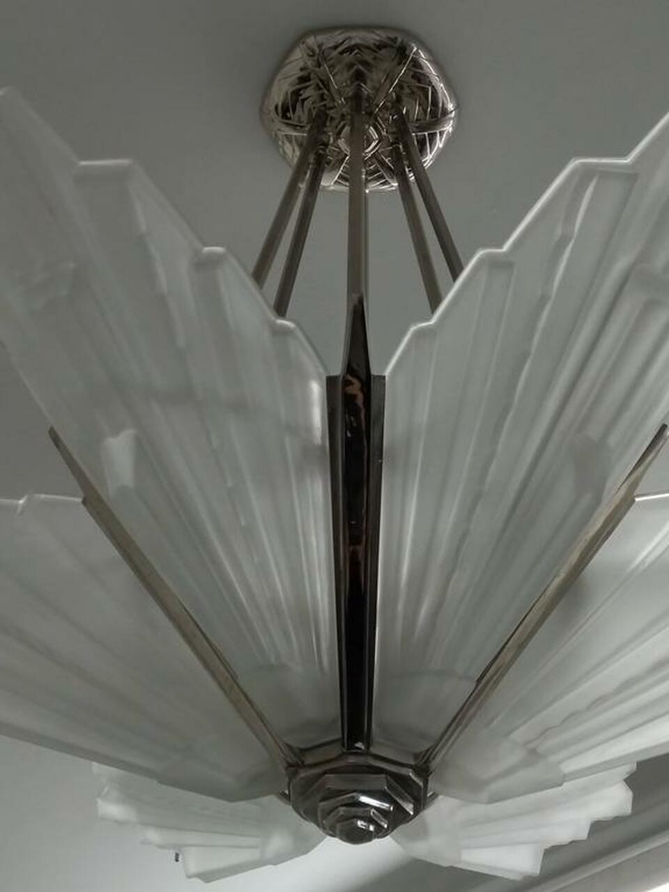 A French Art Deco chandelier with six substantial grand scale by Sabino in great condition. Clear frosted molded glass shades with geometric motif polished details mounted on a nickeled bronze frame with a matching streamlined design frame. Replated