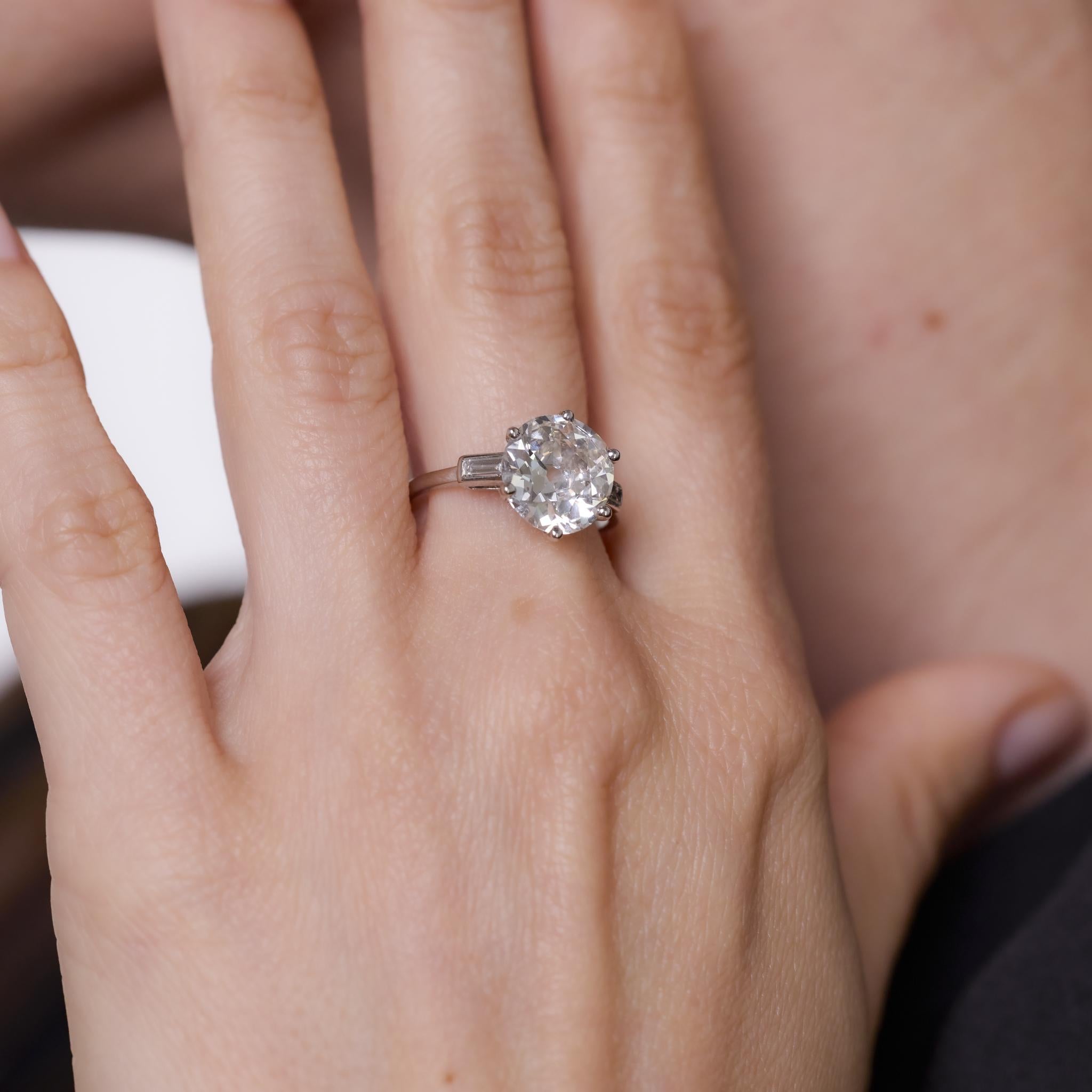 Cette bague Art déco des années 1930 est ornée d'un diamant de taille européenne ancienne de 3,62 carats, certifié par le GIA (#1232567201) de couleur I et de pureté SI2. Flanquée de deux diamants de taille baguette totalisant environ 0,15 carats,