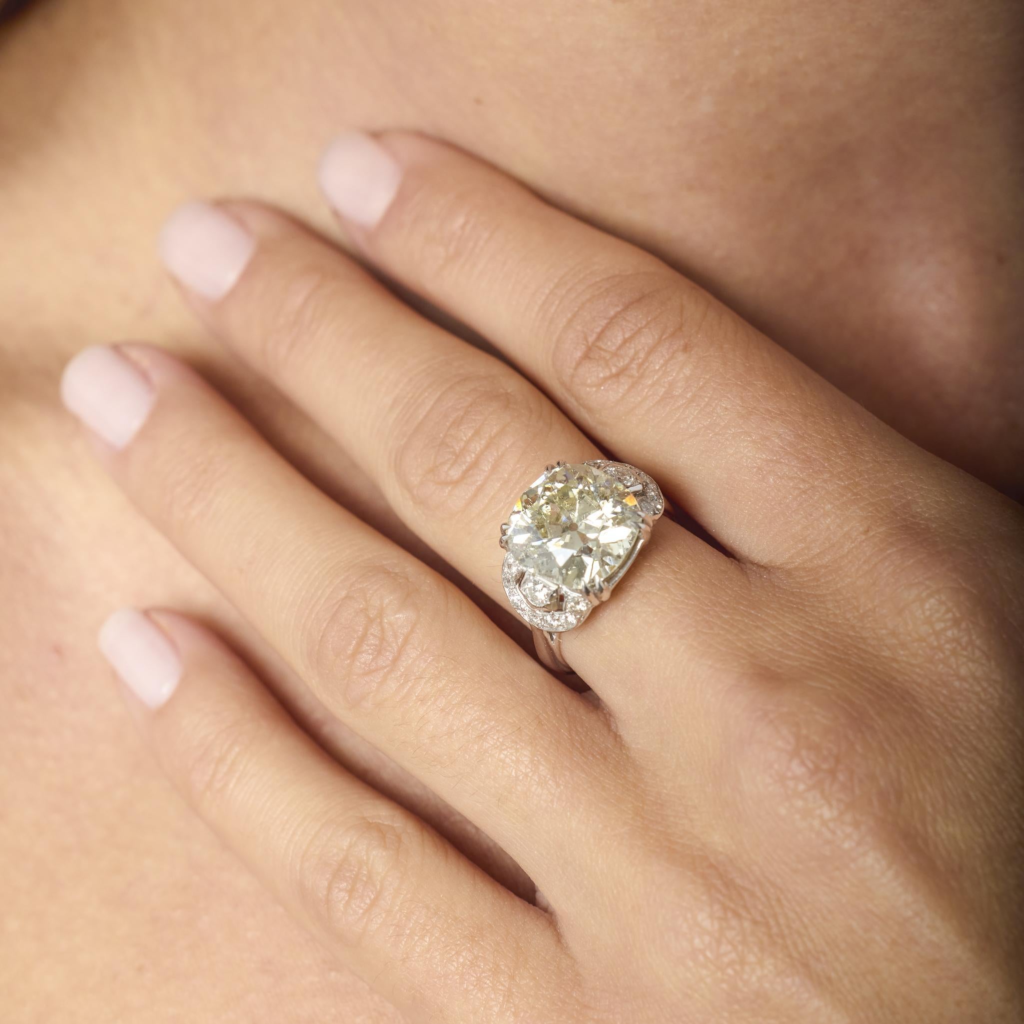 Questo straordinario anello Art Deco presenta un affascinante diamante taglio old mine da 6,38 carati, completato da scintillanti accenti taglio old european in luminoso oro bianco 18 carati: una straordinaria dimostrazione di glamour senza tempo.