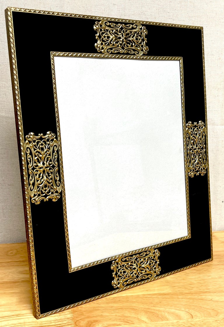 French Art Deco Gilt bronze & black enameled glass picture frame
France, circa 1930s

A glamorous large scale example of period Art Deco, definite of designs by the house of Cartier. This fine frame with four beautiful bold pierced bronze