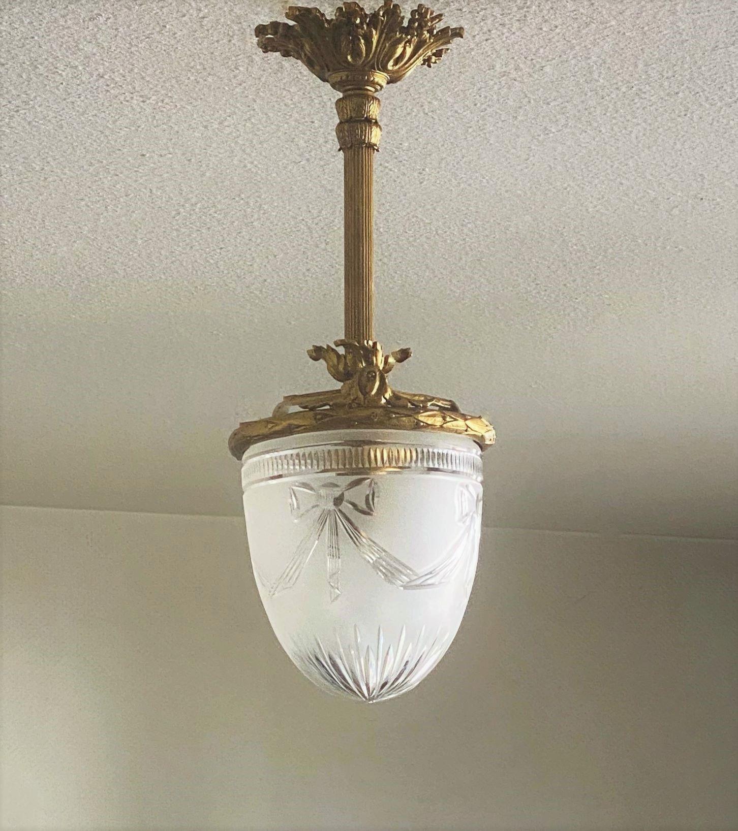 A lovely Art Deco gilt bronze and cut crystal chandelier or flush mount, France, 1920-1929. Bronze elegantly elaborate, crystal shade with cut ribbon motifs, large beautiful ceiling canopy. This wonderful piece is in fine vintage condition, great