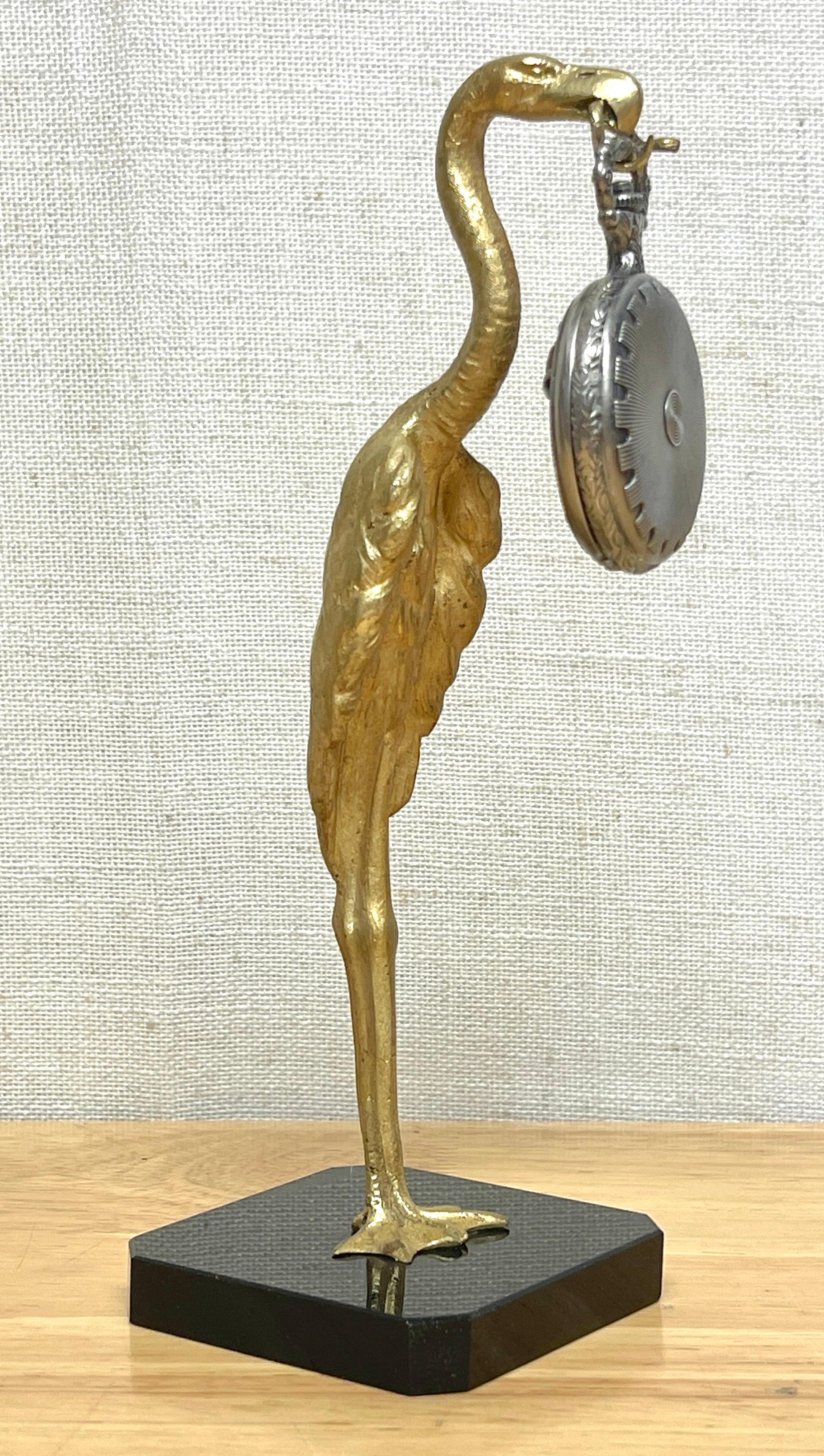 Porte-montre de poche en bronze doré à l'oiseau et au serpent, Art déco français
France, Vers 1920
Figurine en bronze doré coulée et modelée de façon réaliste représentant un grand échassier debout, tenant peut-être un flamant ou une cigogne, avec
