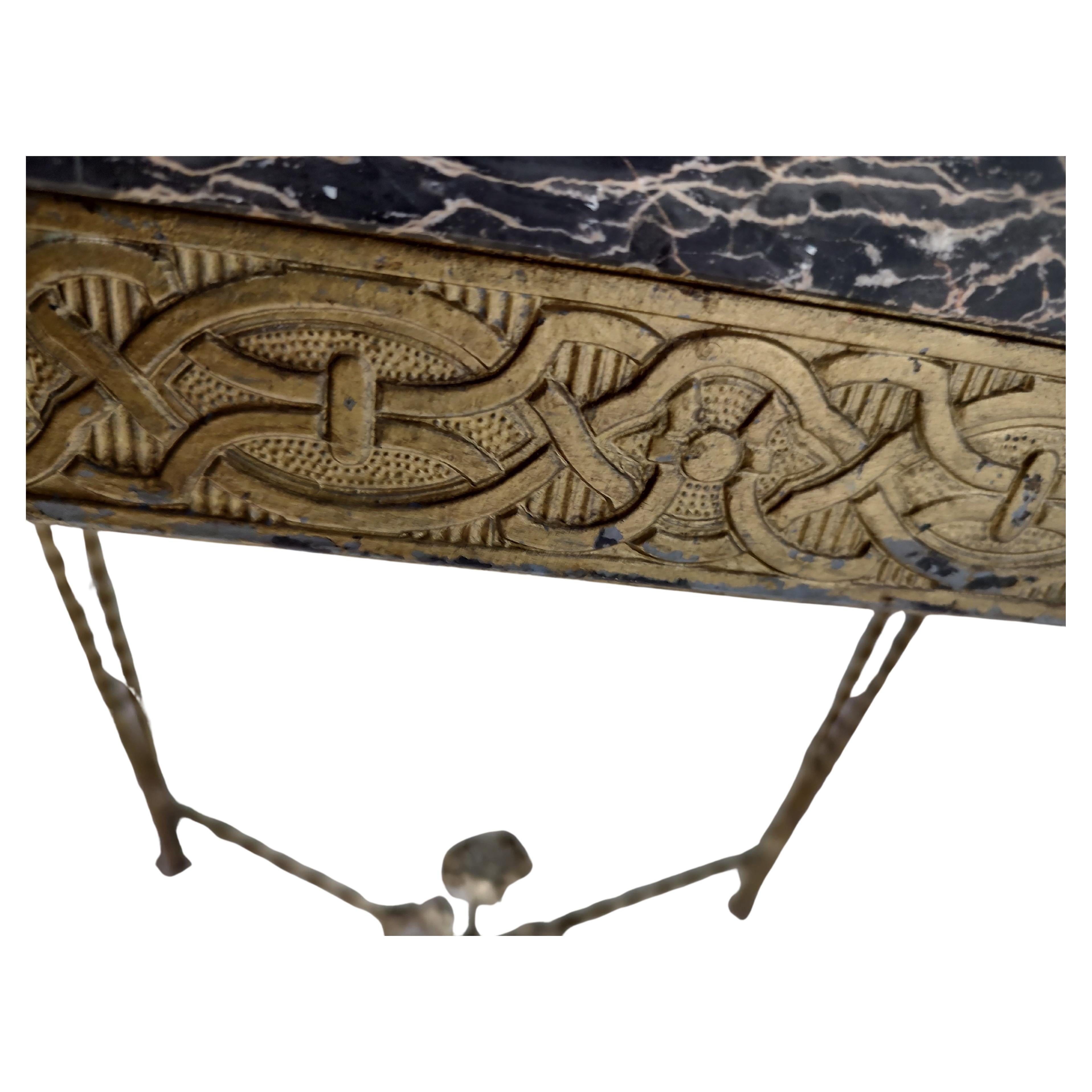Semplice ed elegante tavolo con piano in marmo fortemente venato e base in ferro dorato. La base in ferro è ricca di decorazioni stampate e fuse. Le gambe in ferro sono ritorte e raddoppiate per garantire bellezza e resistenza. In buone condizioni