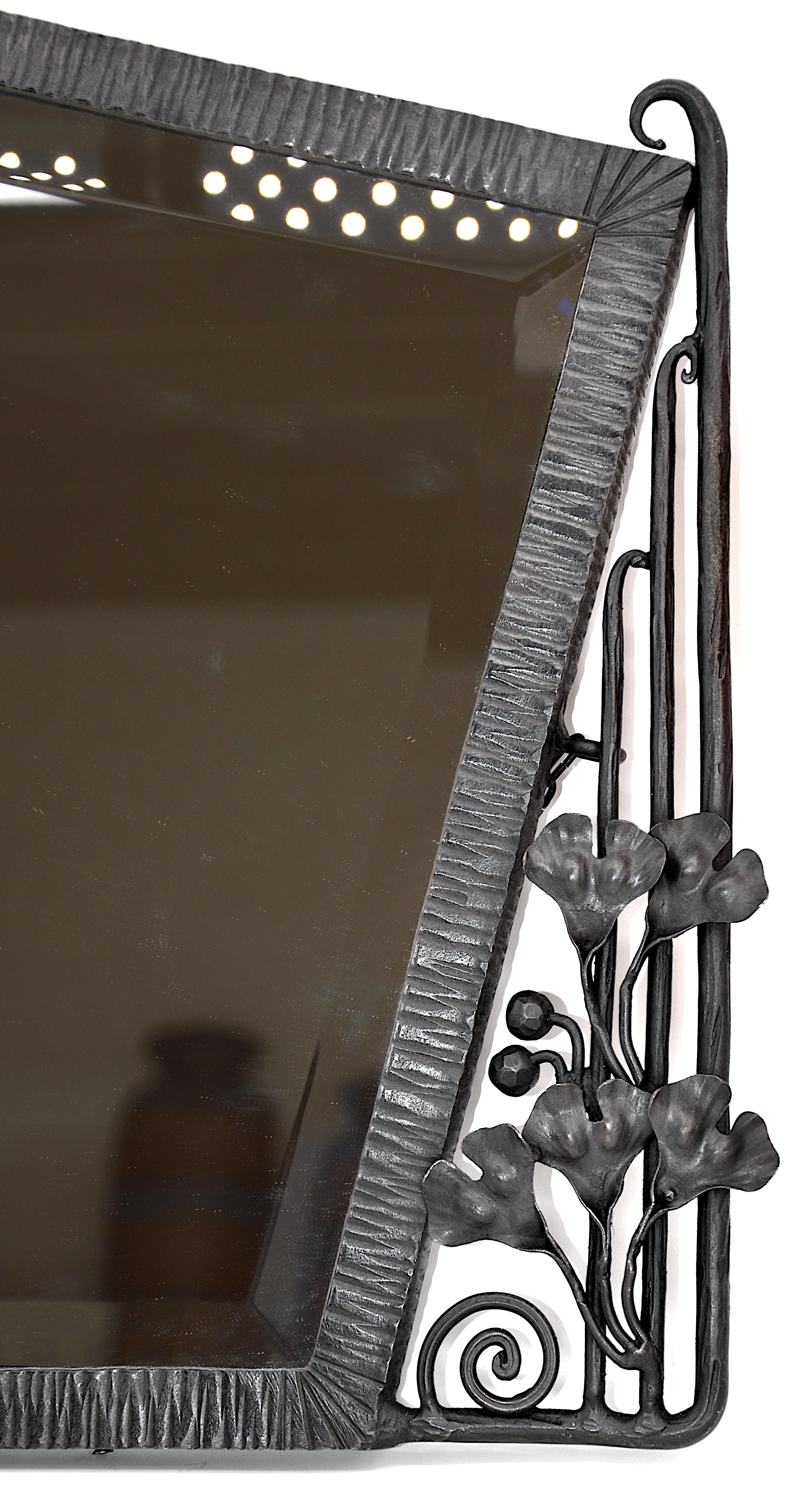 French Art Deco wall mirror, France, ca.1920. Wrought-iron and mirror. Ginkgo biloba fruits and leaves. The worn and stained beveled glass has been replaced by an identical new one. Measures: Width: 25.8