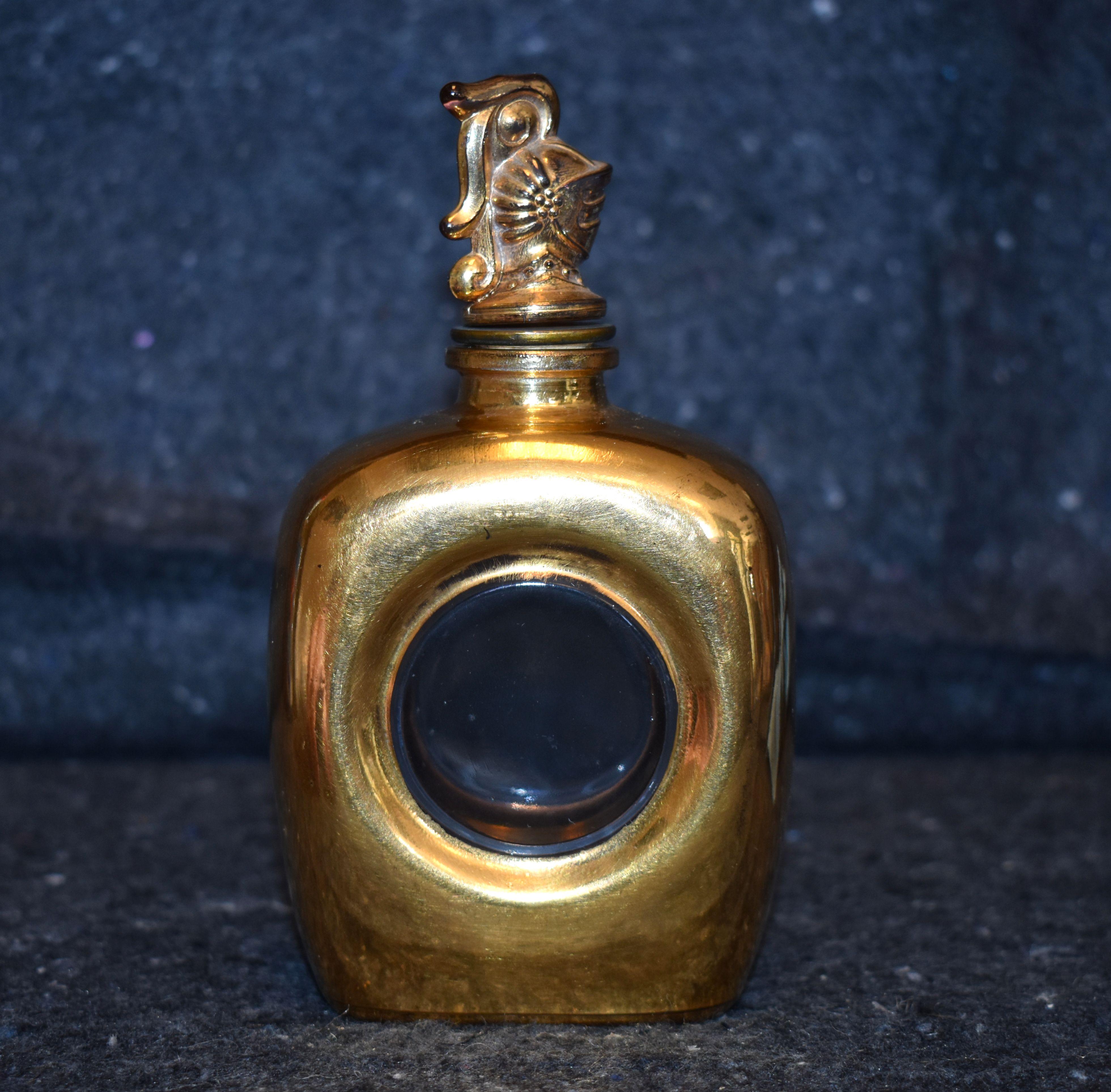 French glass perfume bottle with gold insert. Bottle has a highly detailed figure of a knight wear a shield.