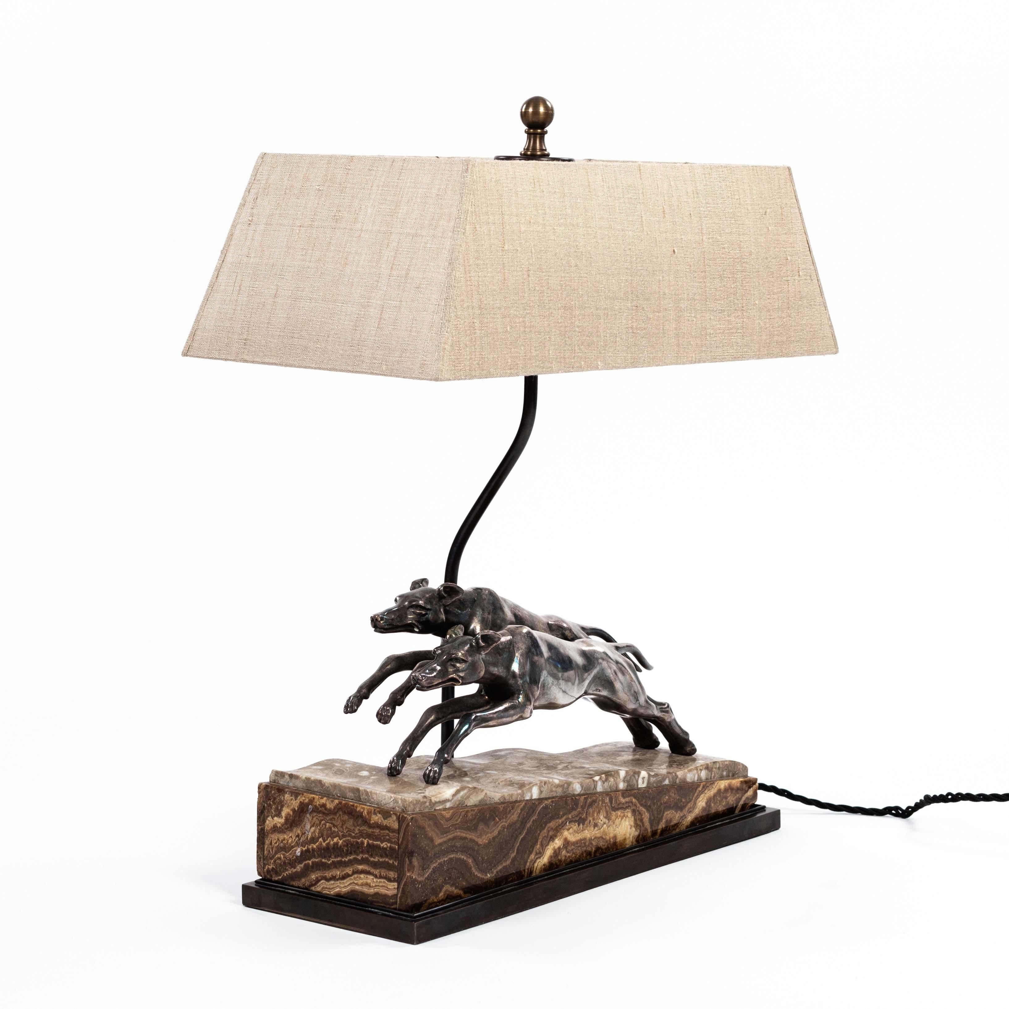 French Art Déco greyhound table lamp in silvered bronze on brown marble base 1930s

Greyhounds from the French Art Deco period as an expression of the luxurious lifestyle of that time.
The animals are in motion the marble base consisting of a