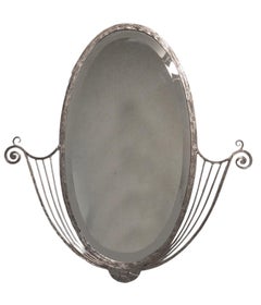 French Art Deco hand wrought nickeled iron oval mirror w/ linear & scroll detail