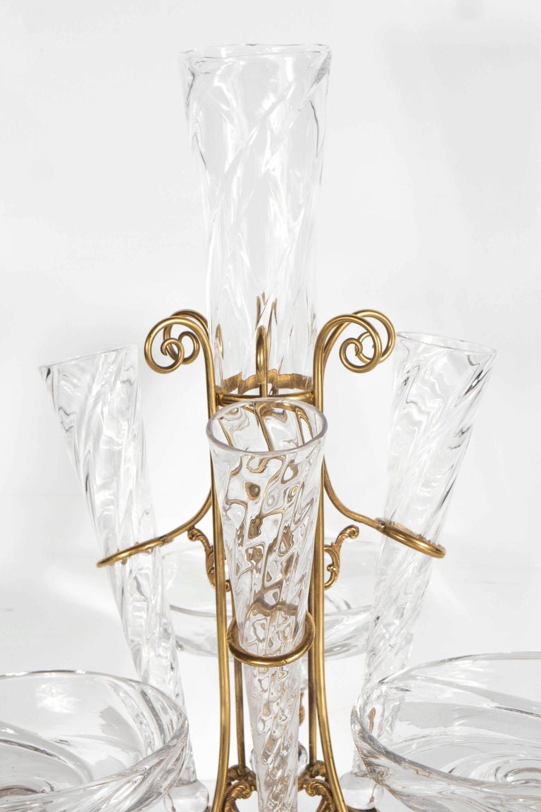 This stunning French Art Deco epergne (typically displayed on a dining table or buffet) was realized in France, circa 1930. It consists of a brass frame with neoclassical detailing and scroll forms that supports a larger central fluted form in