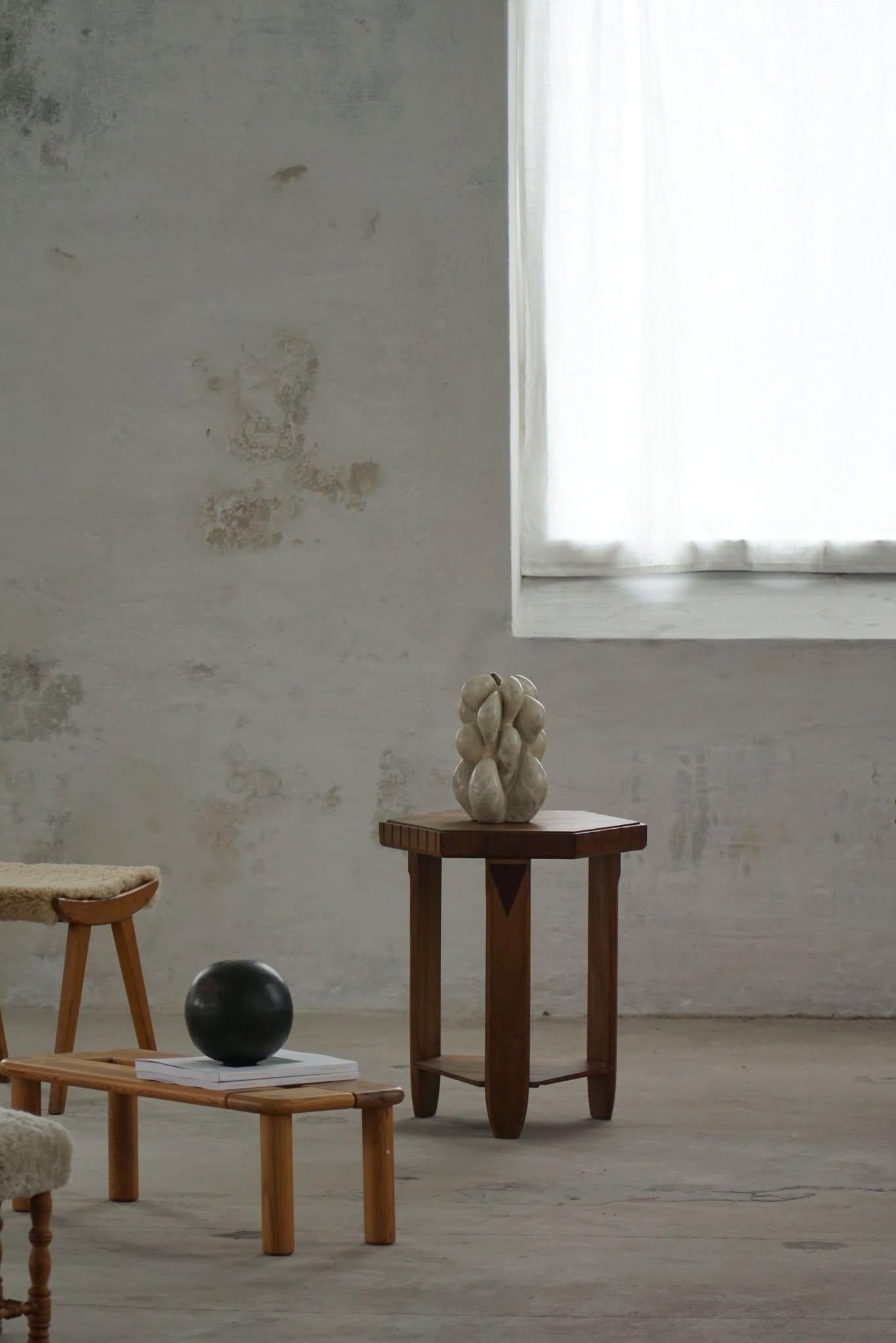 Elegante tavolino francese Art Déco degli anni '30, con piano esagonale e base in caldo legno di noce. Le linee pulite e la forma geometrica riflettono lo stile raffinato dell'epoca. Un pezzo compatto ma di grande effetto, ideale come tavolino