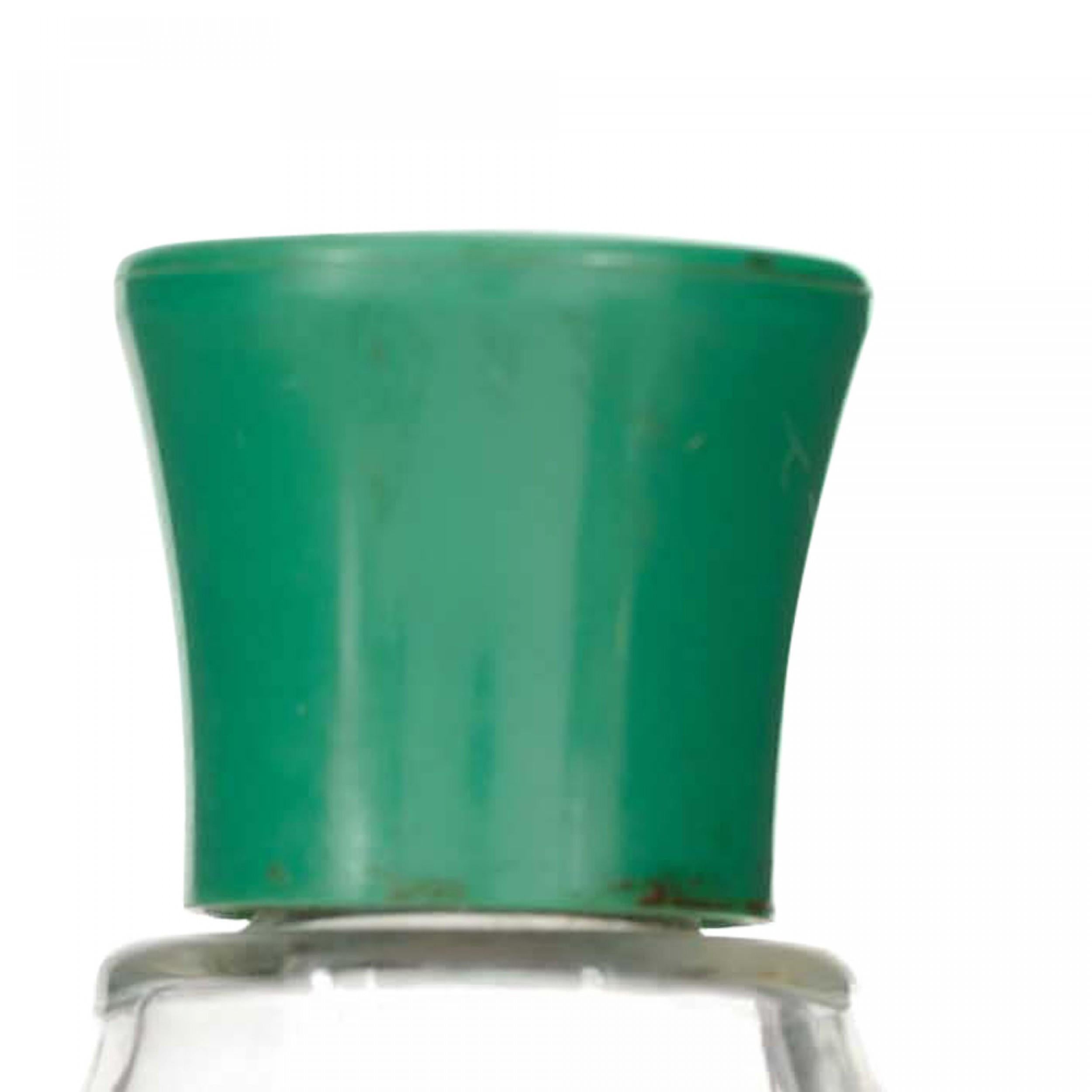 French Art Deco clear glass perfume bottle shaped like a woman\'s foot in a high-heel shoe, with a green plastic stopper.