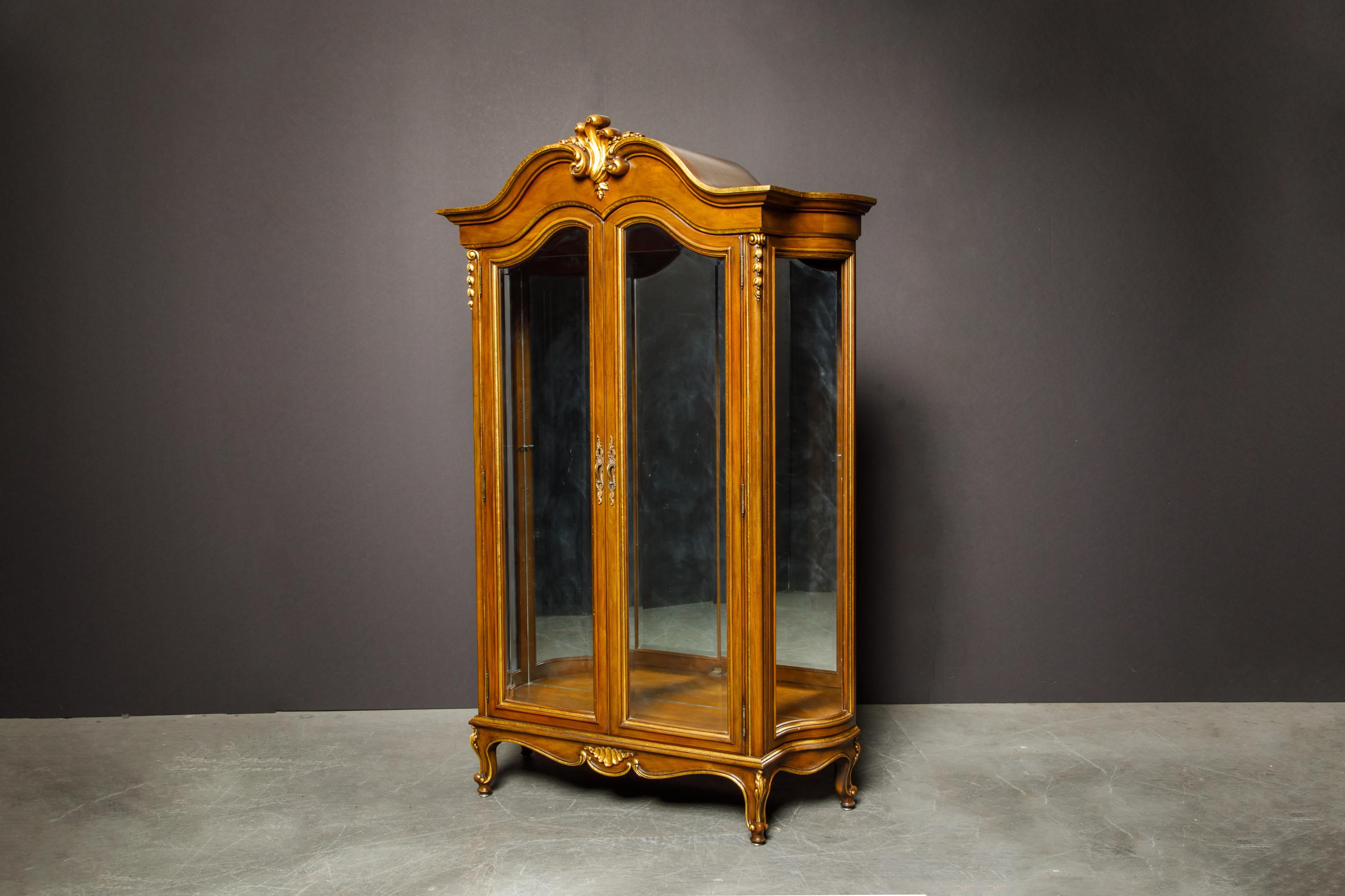 A beautiful gilted French Art Deco vitrine featuring an illuminated and mirrored interior space worthy to place your small treasures to show off to all of your guests, friends and family. 

Note, one side glass panel was broken and needs to be