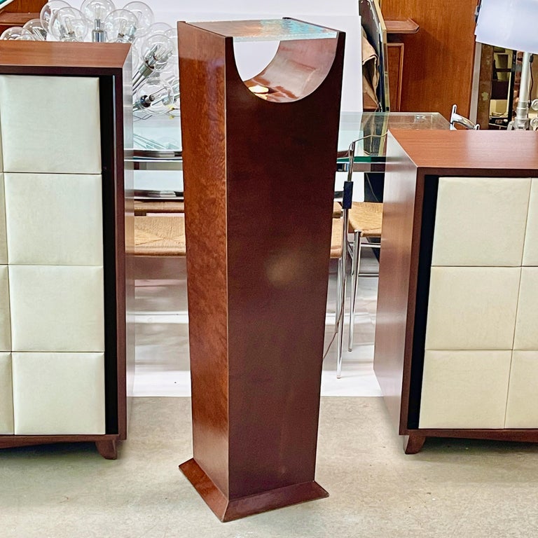 Period French Art Deco pedestal display stand of square tapered form on pyramidal molded base rising to a geometric open half-pipe void of space between two forked sides supporting a square slab of textured glass shelf which is illuminated from